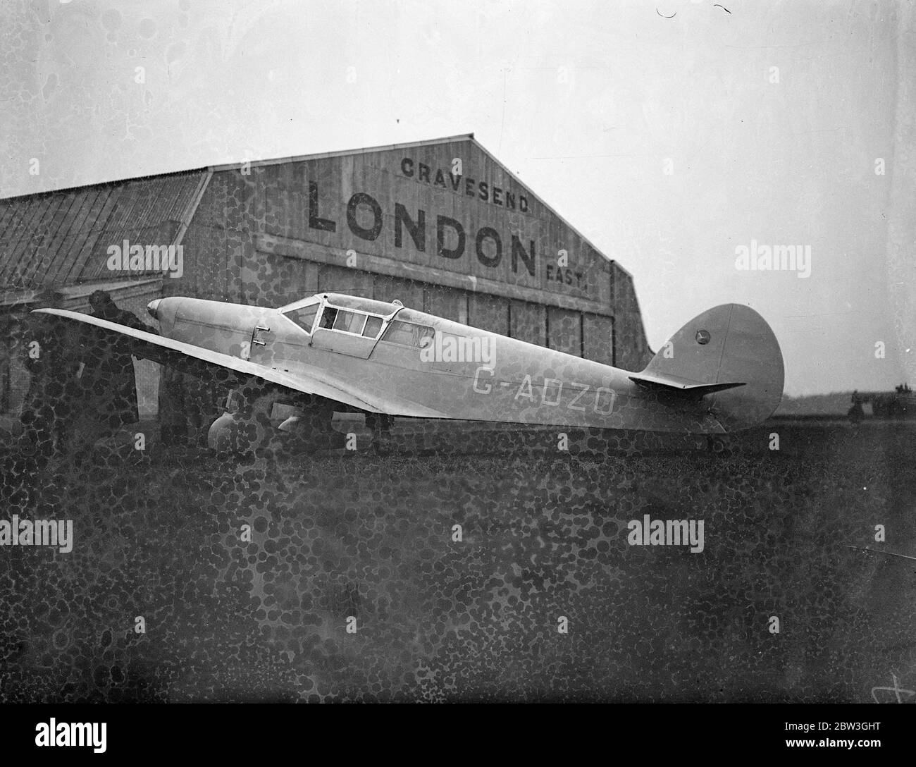 Amy Mollison commence un vol secret pour le Cap . Amy Mollison a fait la plus grande tentative de sa carrière de pilote lorsqu'elle a quitté l'aérodrome de Gravesend à 5 . 40 heures vendredi ( aujourd'hui ) pour voler seul au cap et briser le record de trois jours , 17 heures mis en place par Tommy Rose il ya quelques semaines . Son secret avait été étroitement gardé jusqu'au dernier moment . Photos , avion d'Amy Mollison en face du hangar . 3 avril 1936 Banque D'Images