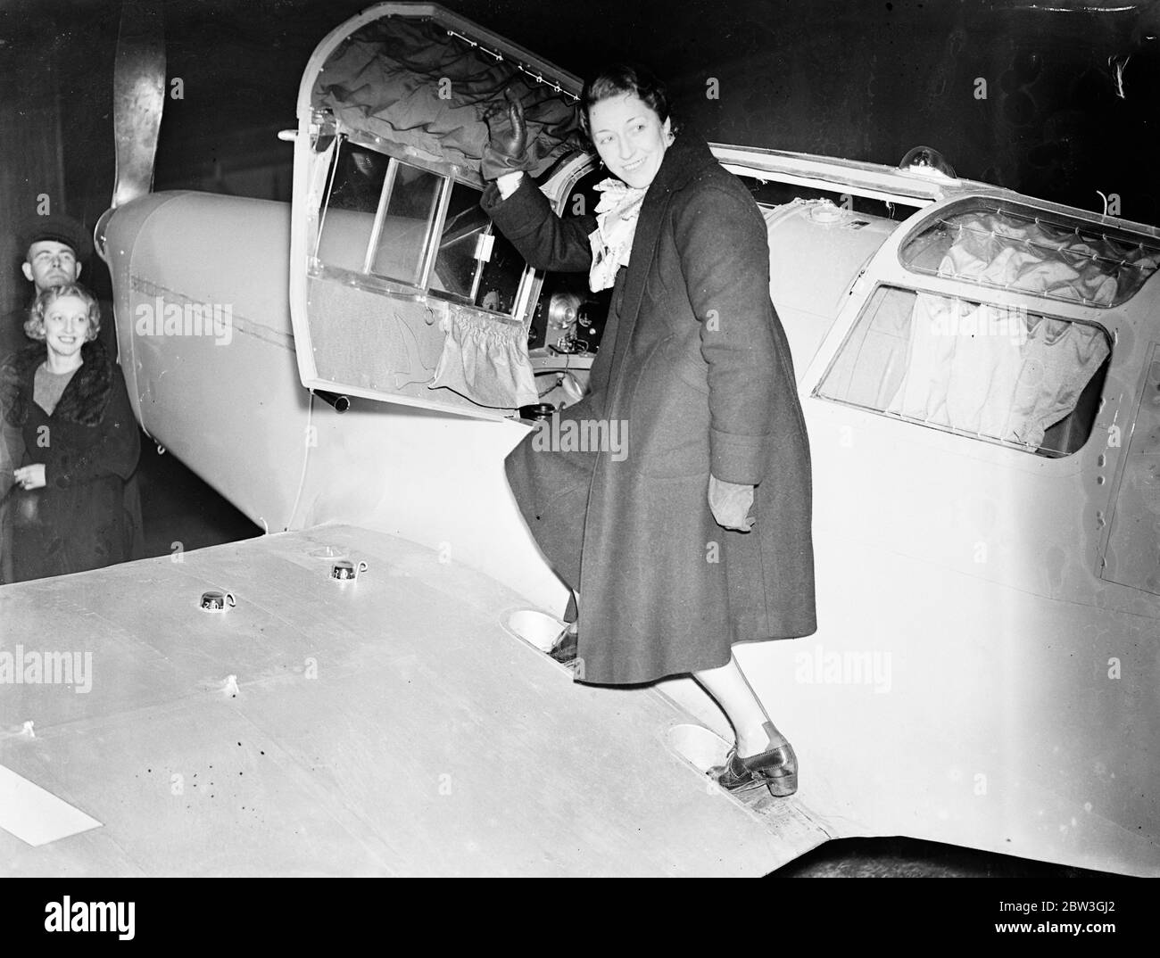 Amy Mollison commence un vol secret pour le Cap . Amy Mollison a fait la plus grande tentative de sa carrière de pilote lorsqu'elle a quitté l'aérodrome de Gravesend à 5 . 40 heures vendredi ( aujourd'hui ) pour voler seul au cap et briser le record de trois jours , 17 heures mis en place par Tommy Rose il ya quelques semaines . Son secret avait été étroitement gardé jusqu'au dernier moment . Photos , Mme Amy Mollison entrant dans son avion au début du vol . 3 avril 1936 Banque D'Images