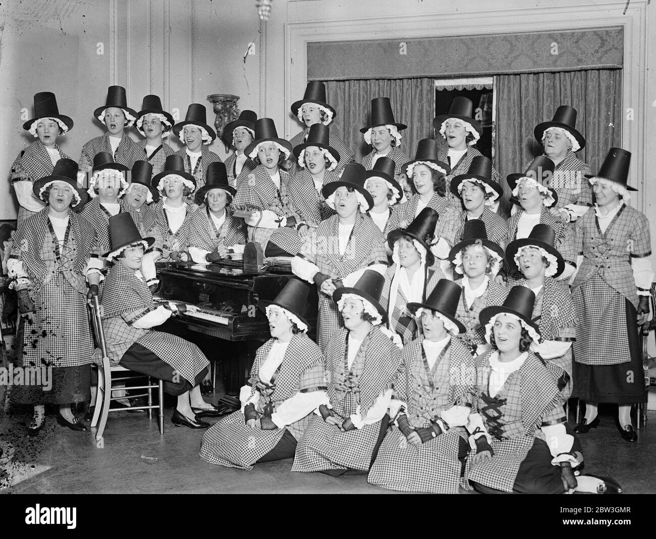 Le chœur royal des femmes galloises répète à Londres avant la chanson du monde . Le chœur royal des femmes galloises que Mme Clare Novelle Davies effectue en tournée du monde du chant répète à la maison de Mme Davies à Londres pour leur tournée . le chœur , Qui espère faire de la tournée une mission de paix , est composé des plus brillants chanteurs que le pays de Galles peut produire . Beaucoup d'entre eux sont des filles du Choeur gallois original qui a tenu captivé une foule de 25 , 000 à Chicago en 1893 . Lors de leur tournée, les filles portent des costumes gallois , de grands chapeaux , et des chaussures bouclées . Photos , le chœur royal des femmes galloises rehe Banque D'Images