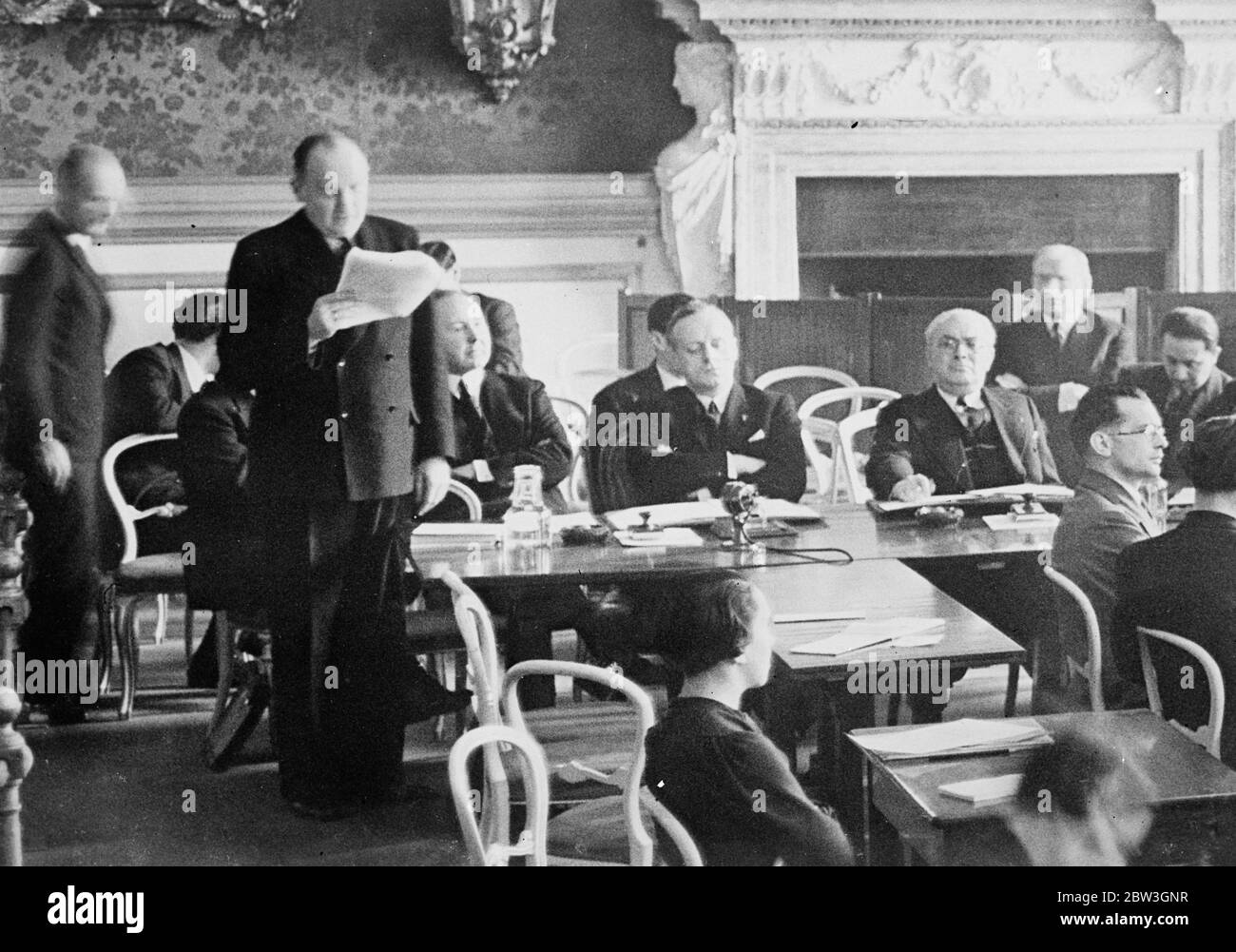Ribbentrop assis . Délégué allemand . 19 mars 1935 un délégué allemand dit que le Conseil de la Ligue Locarno est mort . La réunion du Conseil de la Ligue avec l'Allemagne représentait pour la première fois depuis 1933 . Les délégués allemands sont assis près du mur à l'extrémité gauche de la table . Herr von Ribbentrop a les bras pliés . Banque D'Images