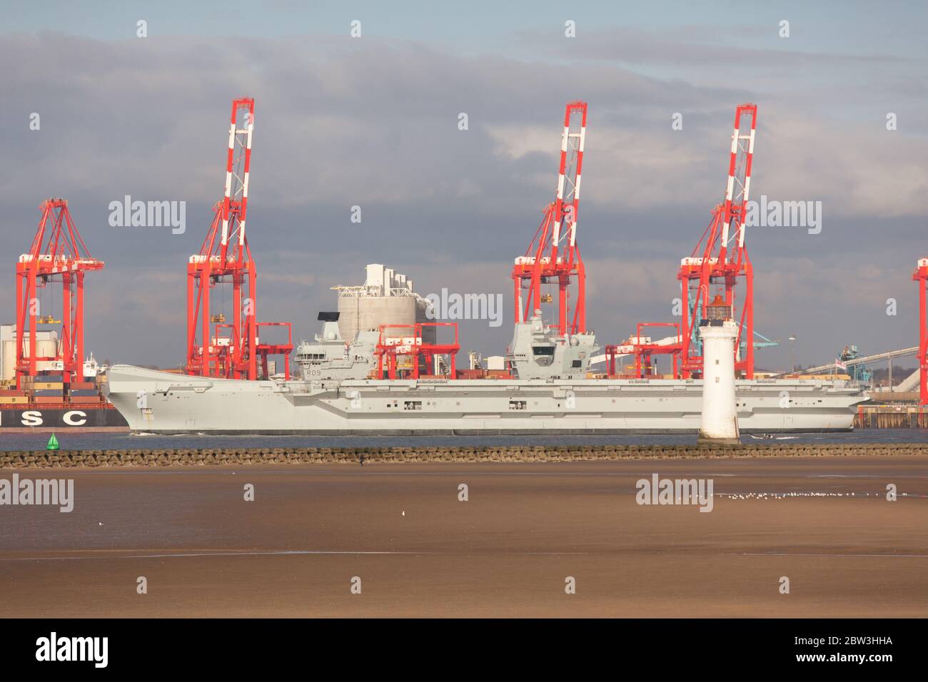 Ville de Liverpool, Angleterre. Le HMS Queen Elizabeth passe devant les grues rouges du terminal de conteneurs de Liverpool, sur la rivière Mersey. Banque D'Images