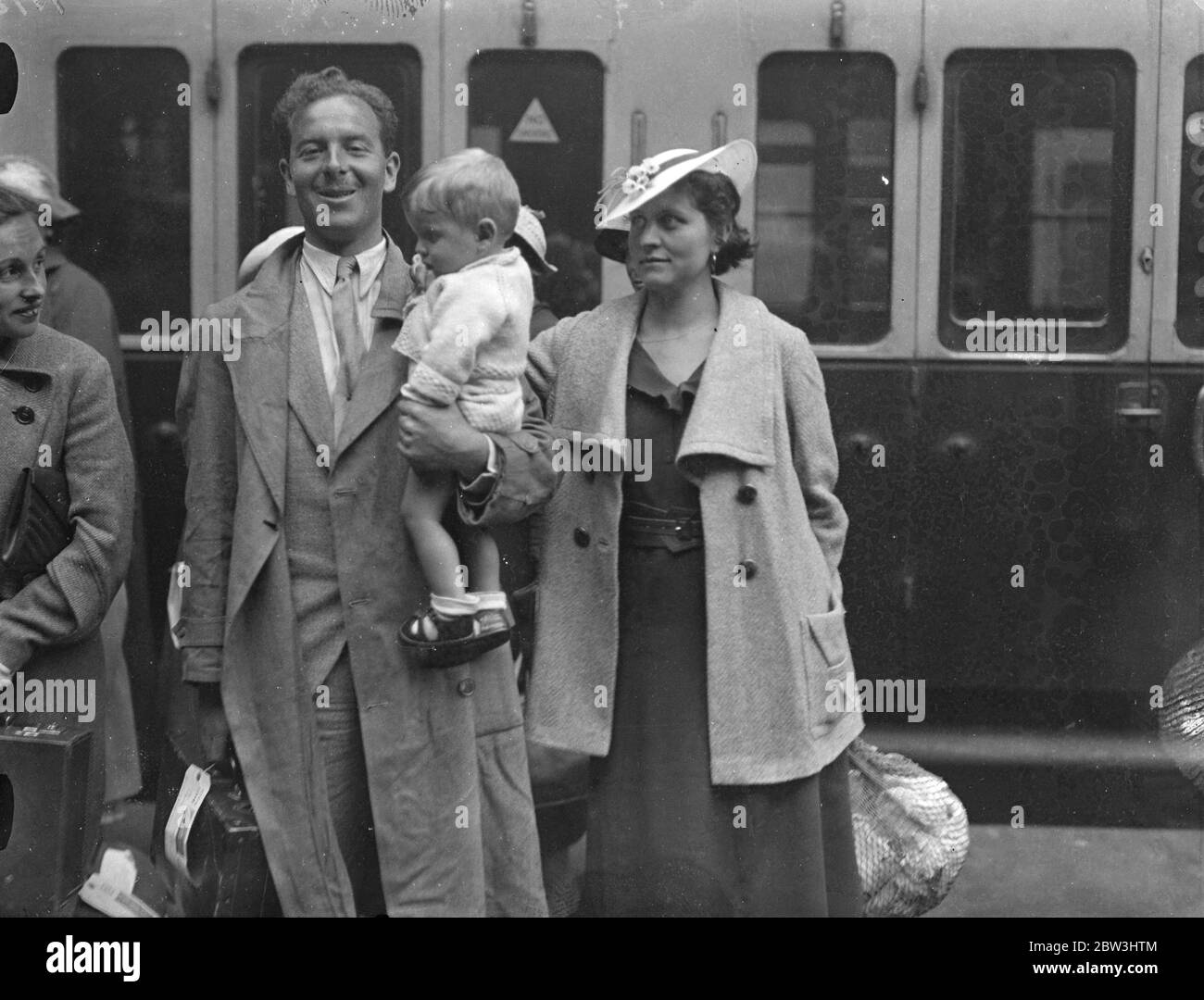 Les réfugiés britanniques de la guerre civile espagnole sont arrivés chez eux. Échappant aux effusions de sang et à l'horreur de la guerre civile espagnole, un groupe de 86 réfugiés britanniques arrivés à la station de remplissage de Barcelone ont été quelques-uns des combats les plus féroces de la révolution. La plupart des membres du parti ont laissé à un si court préavis qu'ils étaient sans argent et qu'ils n'avaient que les vêtements qu'ils portaient. Le ministère de la santé les a rencontrés et est venu à la rescousse, en faisant avancer de l'argent à ceux qui en avaient besoin. Photo size, M. et Mme R V Fulwood , qui vivait en Espagne depuis cinq ans, avec leur bébé à l'arrivée à Paddington Banque D'Images