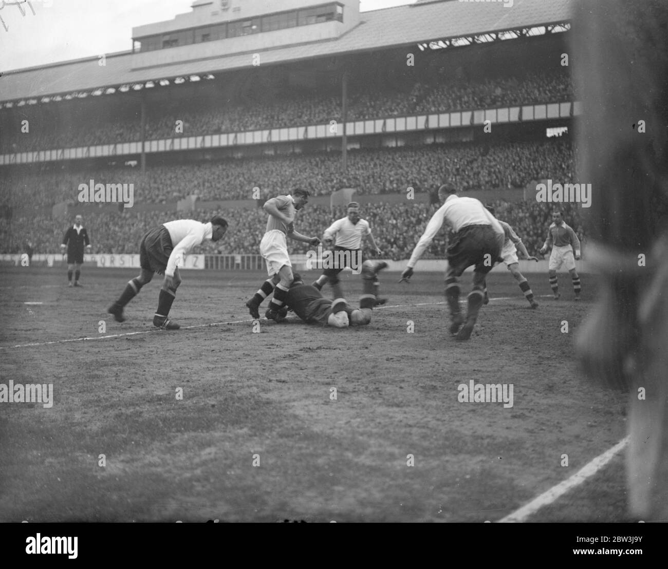 Joseph Nicholls s'en tire dans le match de la division de ligue deux . Nicholls , le gardien de but Tottenham Hotspur , descendant pour sauver de Frederick Sharman et William Coutts de Leicester City dans le match à White hart Lane . 11 avril 1936 Banque D'Images
