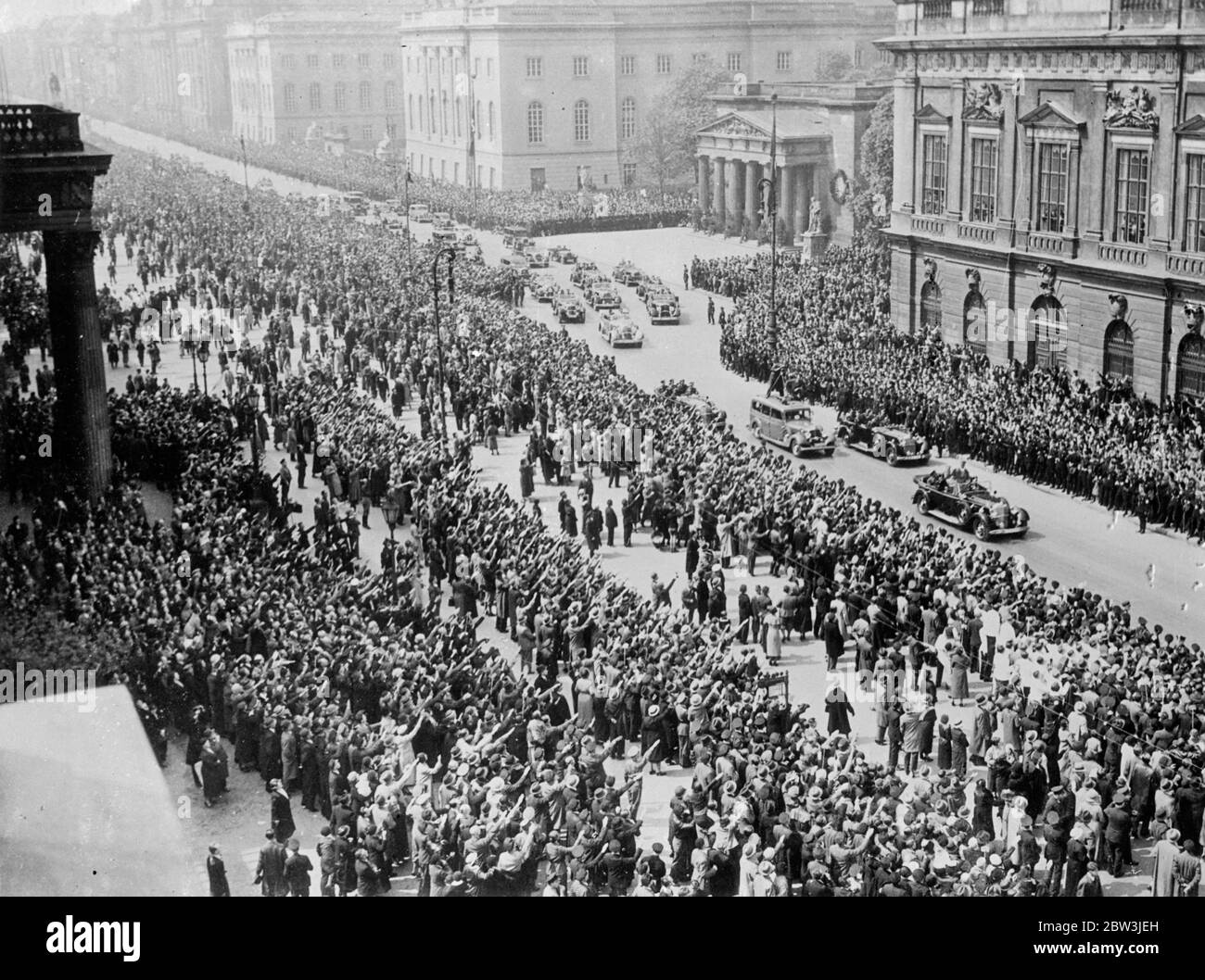 Des millions saluent Hitmer dans les rues de Berlin . Avec 2 , 000 , 000 personnes , s'étendant sur quatre miles , rassemblées pour entendre son discours , le chancelier Hitler a parlé à l'ensemble du peuple allemand des marches du Museam de Berlin sur le Lustgarten à l'occasion de la Journée nationale du travail ( Mai jour ) . Le discours a été reproduit par des haut-parleurs à Berlin et dans tout le Reich . Hitler a dénoncé comme menteurs ceux qui disent que l'Allemagne se prépare à envahir l'Autriche ou la Tchécoslovaquie . ' Je ne conduit pas des millions à être massacrés de sorte que d'autres millions devraient croire en moi ' a-t-il dit . Photos , chancelier frappé Banque D'Images