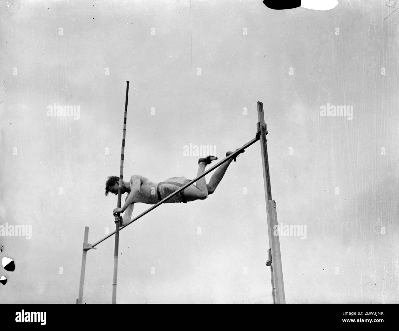 Pratiques de détenteur de documents en anglais Pole VAUL pour UN . A . A . Championnats . Eh bien - des athlètes connus ont pratiqué au stade de White City en préparation pour les championnats de l' Association amateur d'athlétisme qui s'y ouvrent vendredi . Spectacles de photos : F . R . Webster , détenteur du disque anglais à 12 ft . 8 po. en pratique, coffre-fort à perche. 7 juillet 1936 Banque D'Images