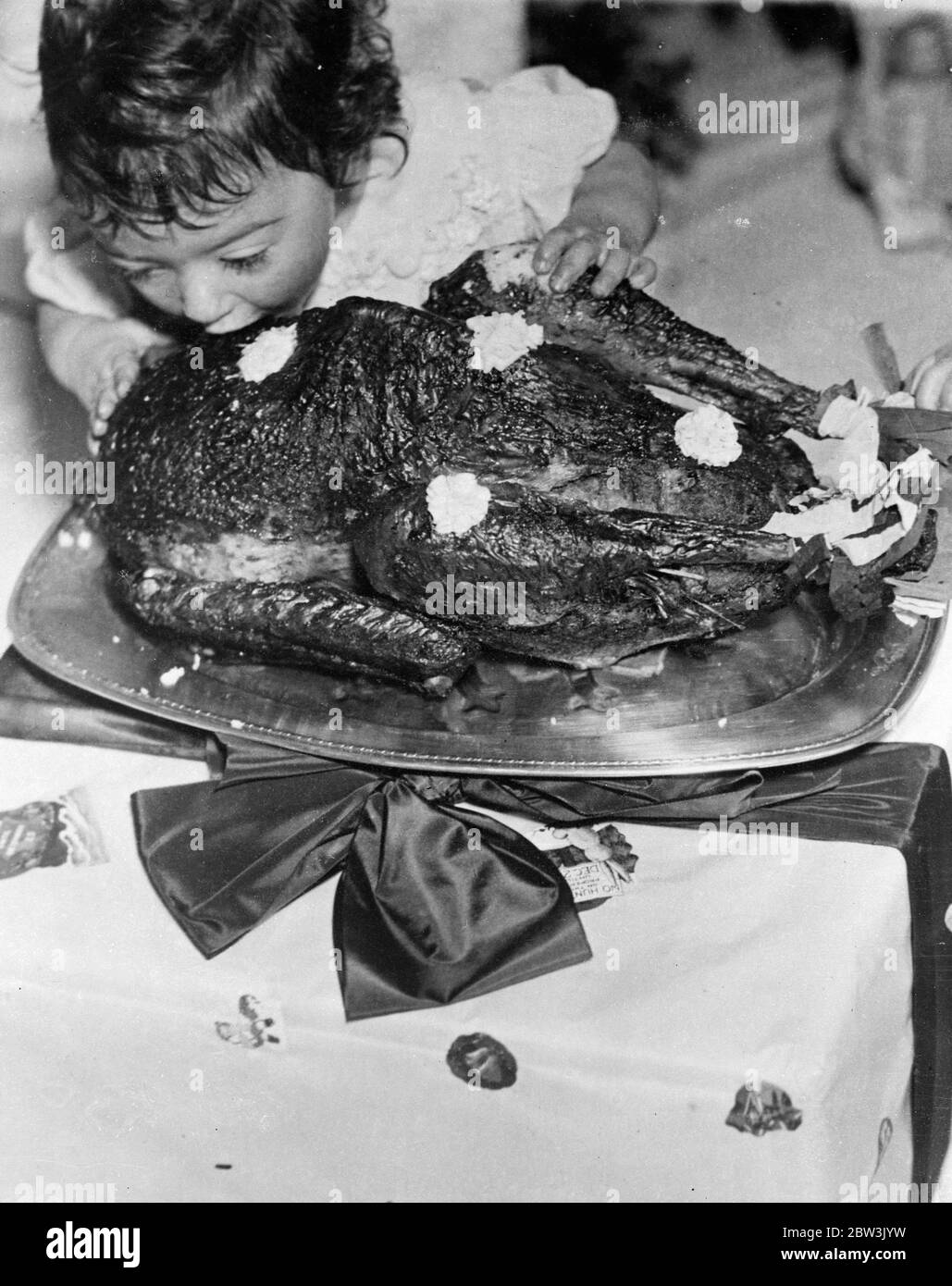 Photos exclusives de la fête de Noël de Dionne Quintuplets . Emelie s'attaque à la turquie par elle-même. 26 décembre 1935 Banque D'Images