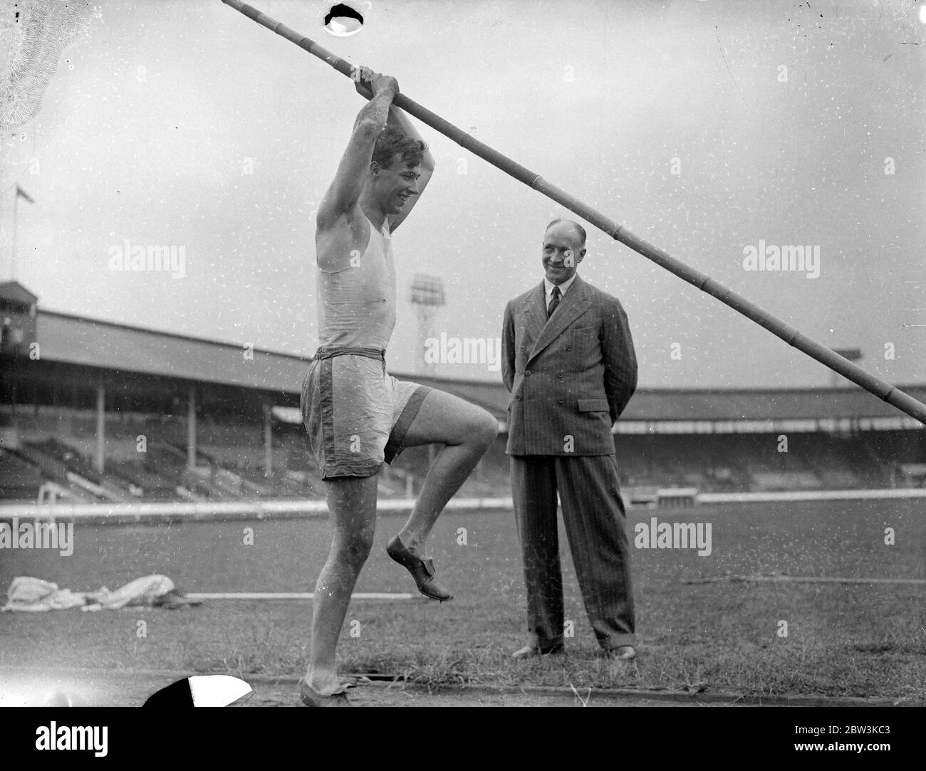 Pratiques de détenteur de documents en anglais Pole VAUL pour UN . A . A . Championnats . Eh bien - des athlètes connus ont pratiqué au stade de White City en préparation pour les championnats de l' Association amateur d'athlétisme qui s'y ouvrent vendredi . Spectacles de photos : F . R . Webster , détenteur du disque anglais à 12 ft . 8 po. en pratique, coffre-fort à perche. 7 juillet 1936 Banque D'Images