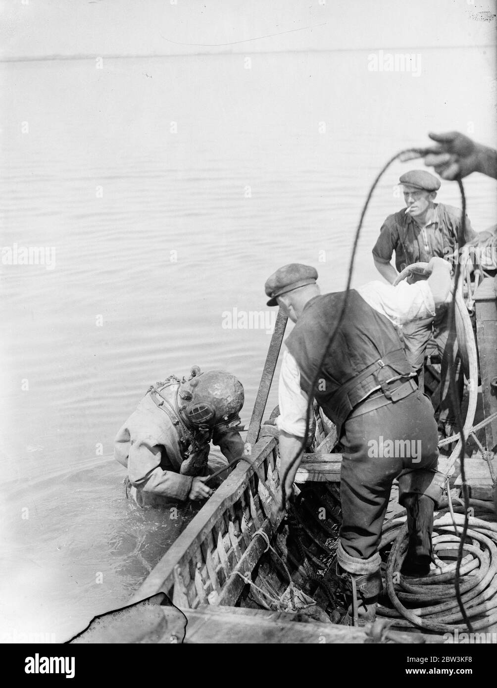 Récupération du HMS bulwark après 21 ans d'explosion mystère en temps de guerre qui a coûté 760 vies . A huit miles de Sheerness des opératons de récupération de l'ancien moniteur Humber ont commencé sur le HMS Bulwak , le navire de guerre coulé par une explosion mystérieuse avec la perte de 780 vies dans les premiers jours de la Grande Guerre . Les plongeurs ont commencé leurs examens de l'épave , qui se trouve sept brasses au fond de la rivière Medway , et une grue à vapeur de 60 tonnes a été érigée pour enlever les précieuses plaques d'acier blindées et les tourelles de canon qui doivent être blalées . Photos montre , le plongeur M. Dan God Banque D'Images