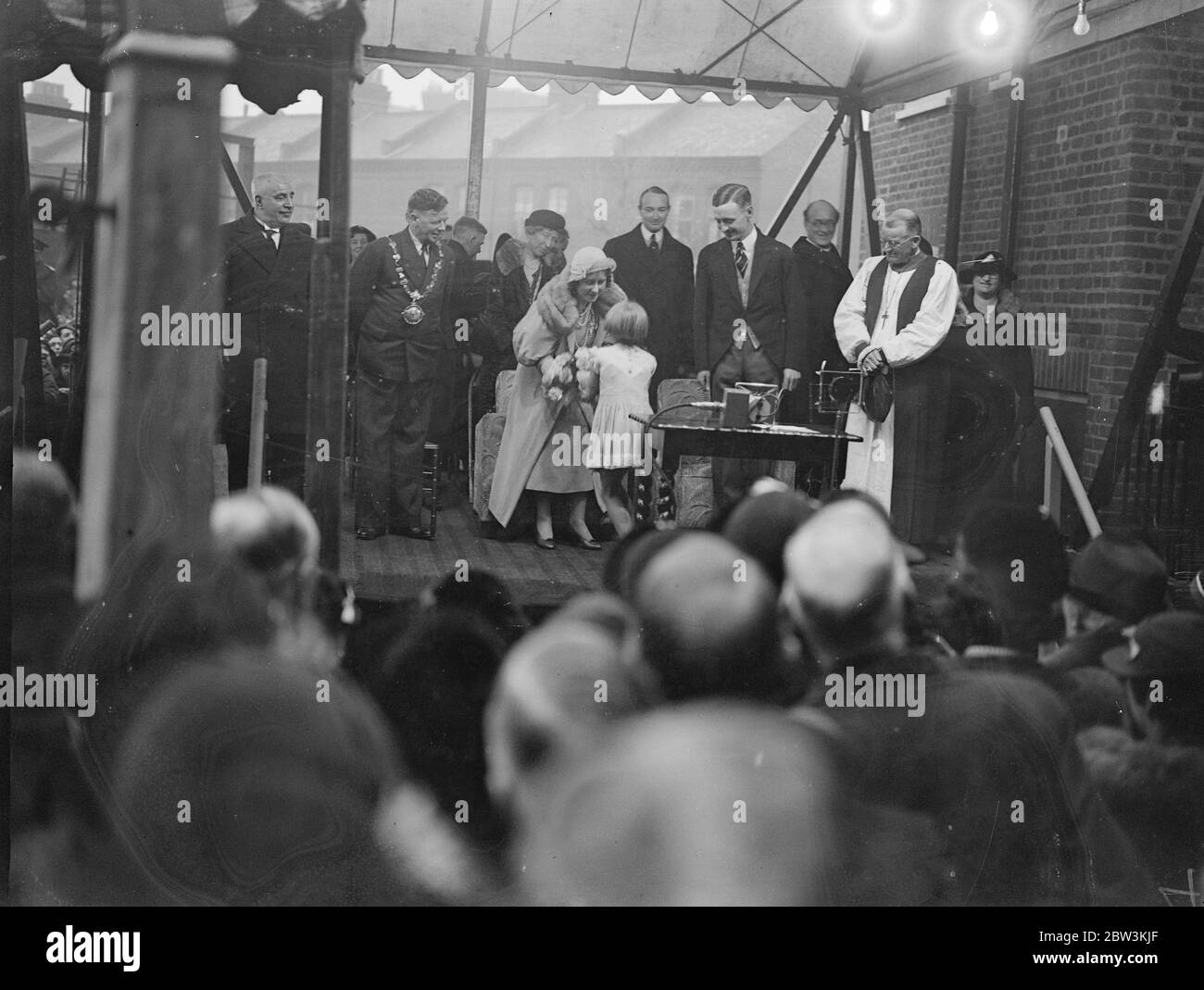 La duchesse de York ouvre de nouveaux appartements à Isle Dogs . La duchesse de York , qui n'a pas pu assister au baptême du bébé prince en raison de l'engagement préalable , ouvre l'île des chiens , le premier bloc d'appartements de la Housing Society à la maison de St Hubert , Janet Street , l'île des chiens . Photos , la duchesse de York recevant un bouquet d'une petite fille lors de la cérémonie d'ouverture . 20 novembre 1935 Banque D'Images