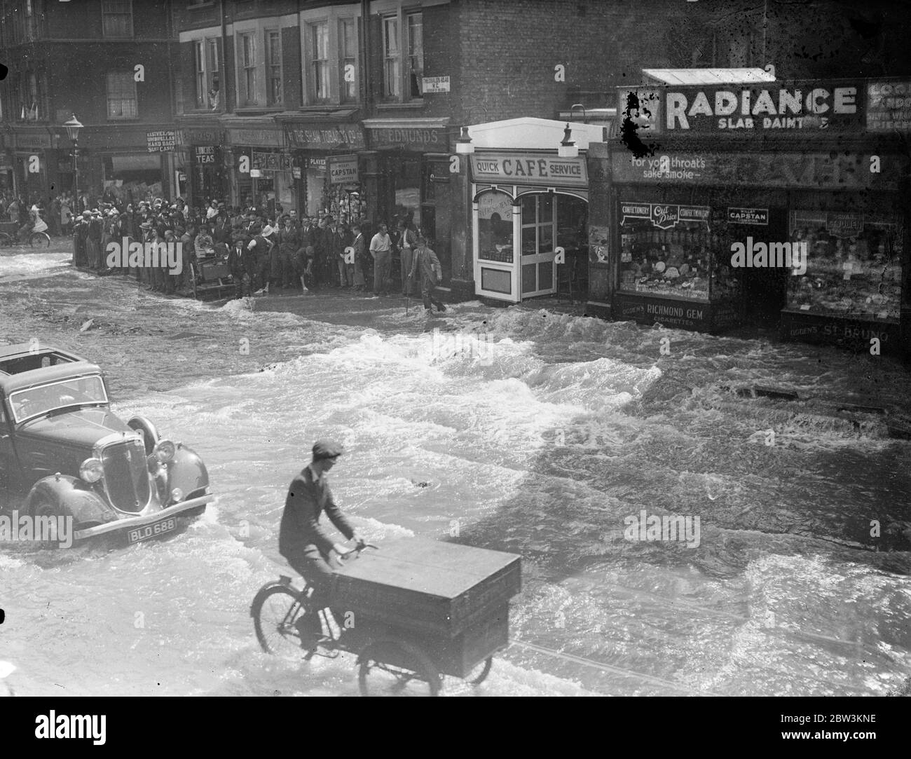 La route de Theobald est transformée en rivière par l'éclatement de la principale eau. Theobald ' s Road a été inondé de Bloomsbury à Holborn par une grande rafale d'eau principale à la fin de Bloomsbury . La surface de la chaussée a été gravement endommagée et la circulation a envoyé des douches de pulvérisation comme il a éclaboussé à travers l'eau connue à Londres pendant longtemps. Photos , la route de Theobald est transformée en rivière par la rafale . 17 juin 1936 Banque D'Images