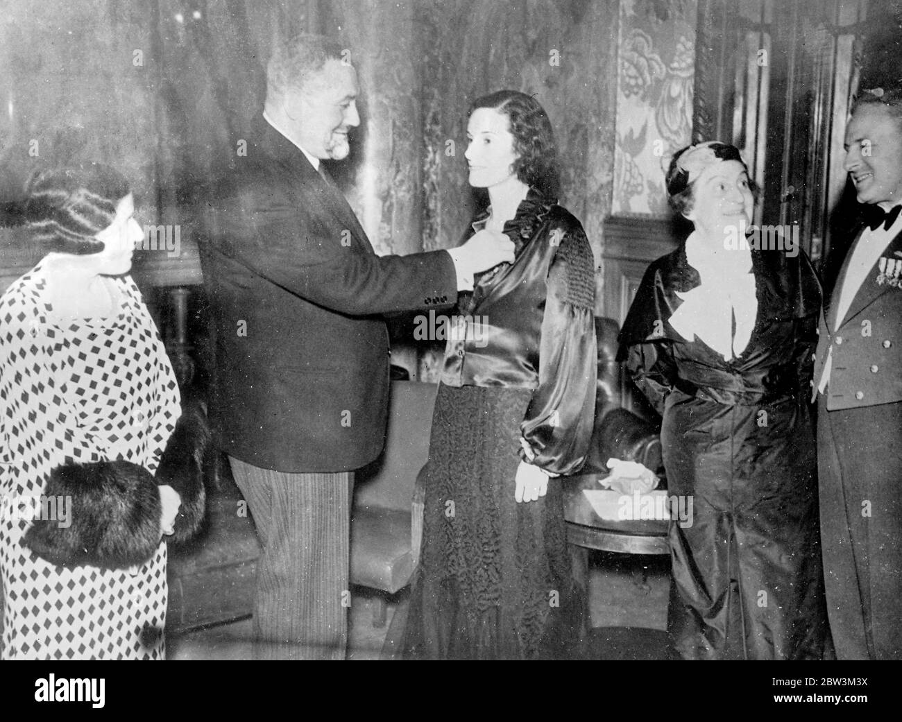 Mlle Jean Batten reçoit la Légion d'honneur . Décoré au banquet en son honneur . Mlle Jean Batten , la jeune fille australienne qui a été la première femme à voler en solo de l'Atlantique Sud , a reçu la décoration de la Légion d'honneur française lors d'un banquet donné en son honneur à l'Aero Club de France à Paris . Elle venait de rentrer avec sa mère d'un vol en Espagne et en Afrique du Nord. Photos Miss Jean Botten recevant la décoration de M Watteau , Président de l'Aero Club de France . De gauche à droite Mlle Deutsch de la Maurthe , M Watteau , Mlle Jean Batten , la Marquise de N. Banque D'Images