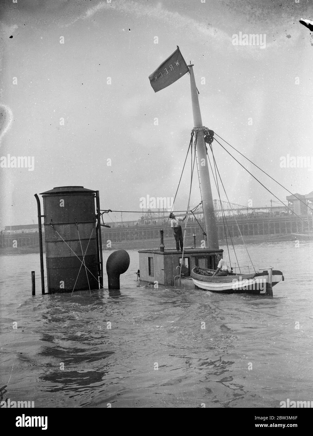 Sauve hommes de P L A préparant le navire à vapeur épaté pour élever le Cragside dans la Thame . Administration du port de London , des briquets d'épave ont commencé des opérations de récupération sur le navire de la compagnie de navires à vapeur Tyne Tans Cragside ( 458 tonnes ) qui a coulé dans Gallions Reach , à l'extérieur de l'Albert Dock après une collision avec 8the S S Ladura ( 9 , 032 tonnes ) Appartenant à la Compagnie de navigation à vapeur de l'Inde britannique . Photos montre , l'équipage de récupération du P L UN épave plus léger préparant le navire à vapeur d'épave pour lever . 9 août 1935 Banque D'Images