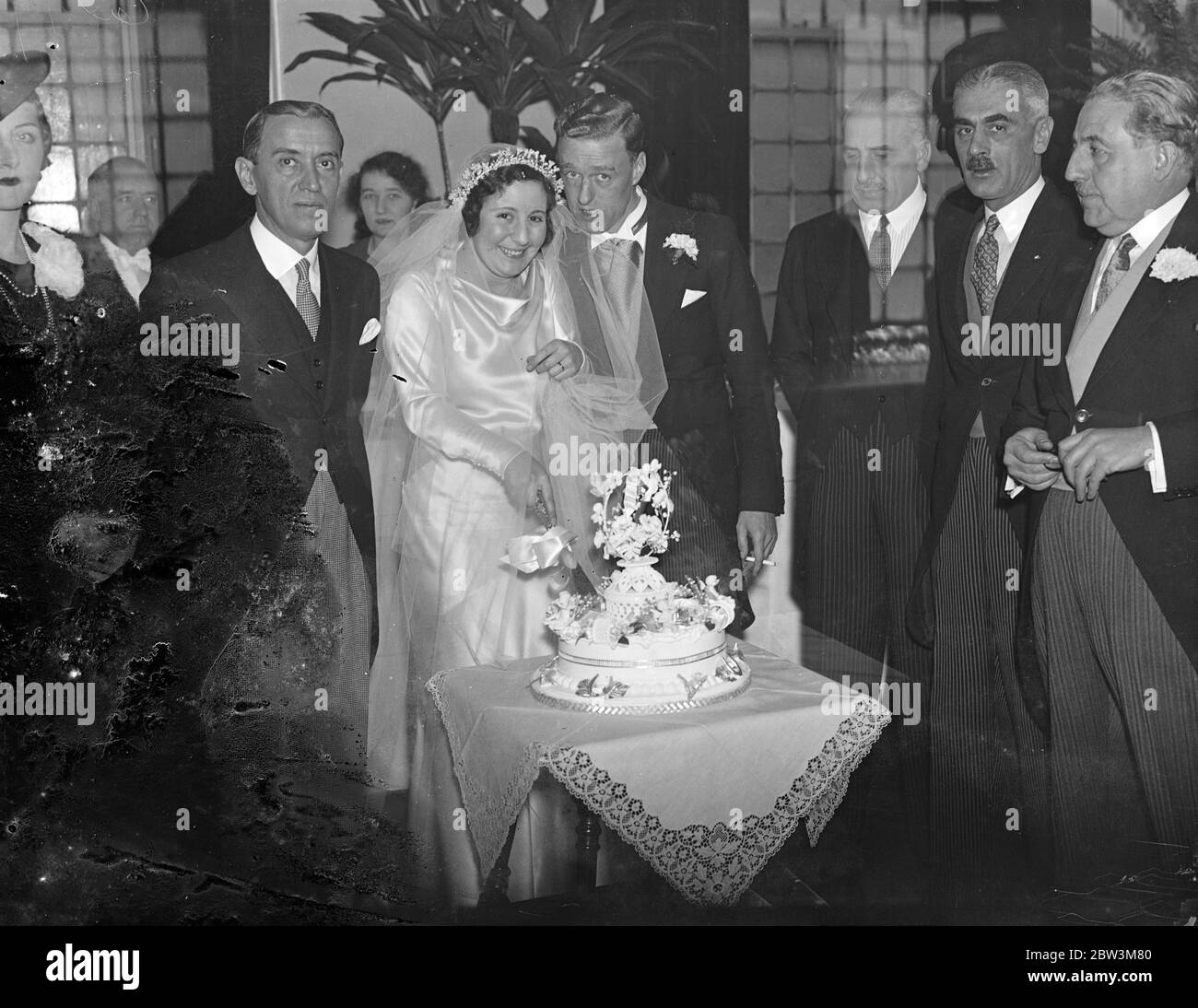 Ambassadeur d'Espagne au mariage Anglo espagnol . Le mariage de Senorita Matilde de Baeza , fille de Senor Luis de Baeza , auteur espagnol qui est aussi un anglophile , à M. Leonard Judge , a eu lieu à toute église de Souls , Langham place . L'Ambassadeur d'Espagne et de nombreux membres de la colonie espagnole de Londres ont assisté au mariage . Photos , la mariée coupant le gâteau , regardée par le marié et l'ambassadeur espagnol ( à gauche ) Senor Ayala . 30 novembre 1935 Banque D'Images