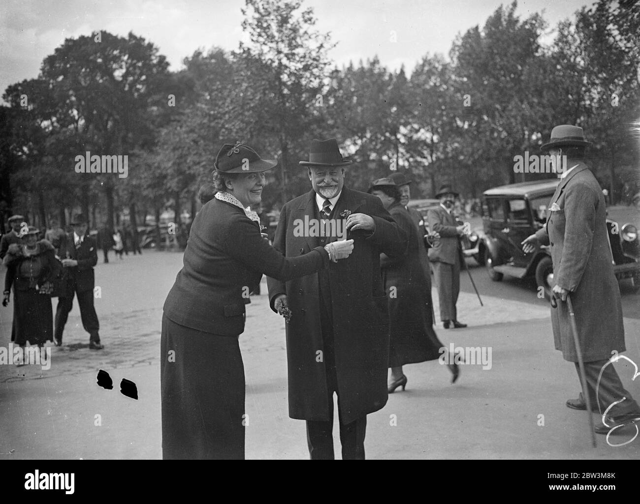 Les suffragettes françaises ont une démonstration en chambre à la réunion du nouveau Parlement . Une manifestation inattendue de suffragettes a été faite dans les gaileries de la Chambre française lorsque le nouveau Parlement s'est réuni pour la première fois à Paris . Amis des roars de l'acclamations des bancs de l'aile gauche , les femmes assises dans les galeries publiques ont défurré une forêt de banderoles inscrites avec ' les femmes françaises doivent voter ' . Photos , Louise Weise , chef du mouvement des suffragettes françaises , tient M Fernand Bouisson , président de la dernière chambre , pour épingler une branche de fleurs sur son trou de boutons après que la Chambre ait ressuscité . Banque D'Images