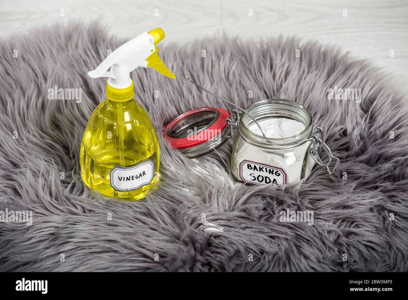 Vaporisez du vinaigre blanc dilué avec de l'eau et du bicarbonate de soude (bicarbonate de sodium) dans un pot en verre. Nettoyage et élimination des taches des tapis à poils longs. Banque D'Images