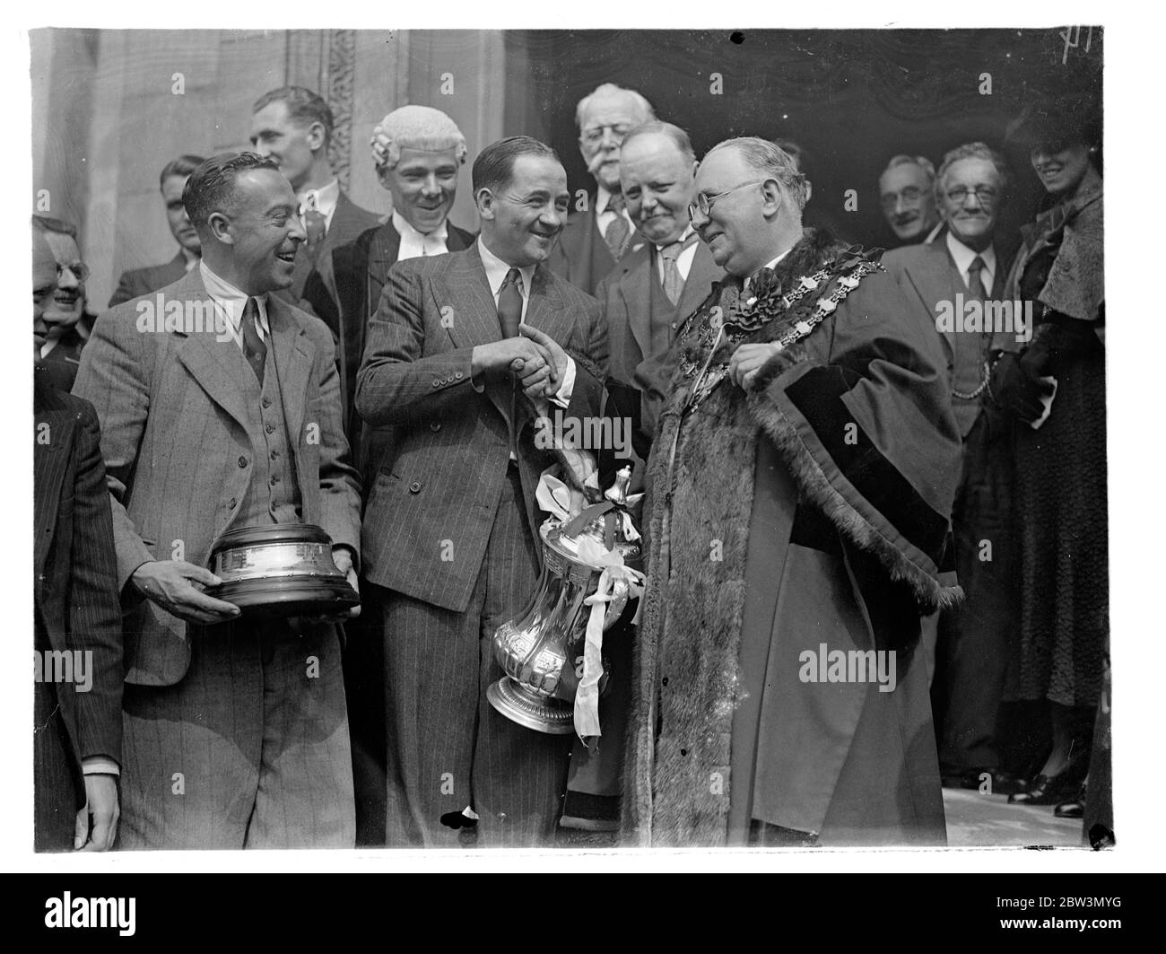 L'équipe d'Arsenal a reçu la réception civique à Islington . Traversez des rues bondées. L'équipe d'Arsenal , les vainqueurs de la coupe d'Angleterre , portant la coupe F A , a traversé de grandes foules jusqu'à l'hôtel de ville d'Islington , où ils ont reçu une réception civique . L'équipe a été reçue par le maire , le conseiller H G Coleman , lui-même un vieux footballeur , à l'hôtel de ville . Photos , Alex James , le capitaine d'Arsenal , reçu par le maire d'Islington , le conseiller H G Coleman , à l'hôtel de ville . 28 avril 1936 Banque D'Images