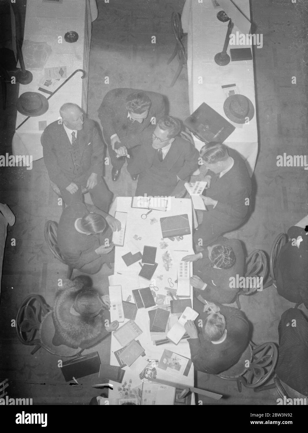 Des concessionnaires du monde entier à Londres Timbre dealers bourse . Des revendeurs de toutes les parties du monde assistent au neuvième marché international de timbres de Londres qui a ouvert ses portes au restaurant Holborn . Des millions de timbres changeront de mains pendant les trois jours de la bourse , les prix étant appelés dans de nombreuses langues et devises . Expositions de photos , examen des timbres à la bourse . 27 avril 1936 Banque D'Images