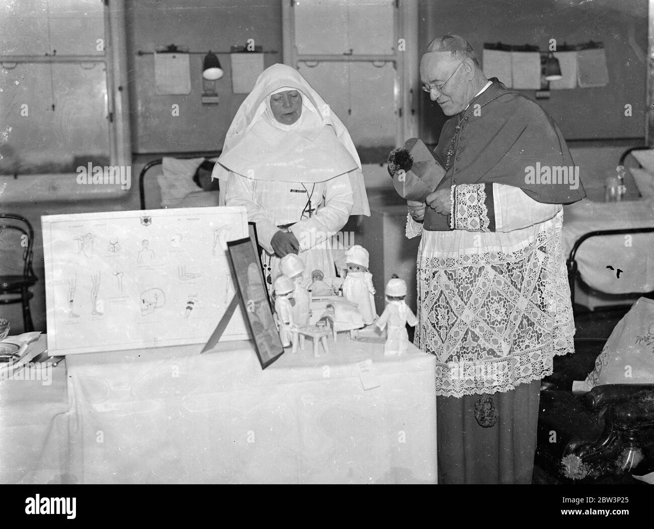 L'archevêque de Westminster célèbre la fête patronale à l'hôpital St Andrew . L'archibishoip de Westminster , le Dr Hinley , a visité l'hôpital St Andrews à Dollie Hill , pour célébrer la fête de la Patrosal . L'archevêque a inspecté un modèle de chirurgie construit par les infirmières montrant divers processus de chirurgie plastique . Photos , le Matron de l'hôpital St Andrews , sœur Mary Ignstius , expliquant une exposition au Dr Hinsley , archevêque de Westminster . 1er décembre 1935 Banque D'Images