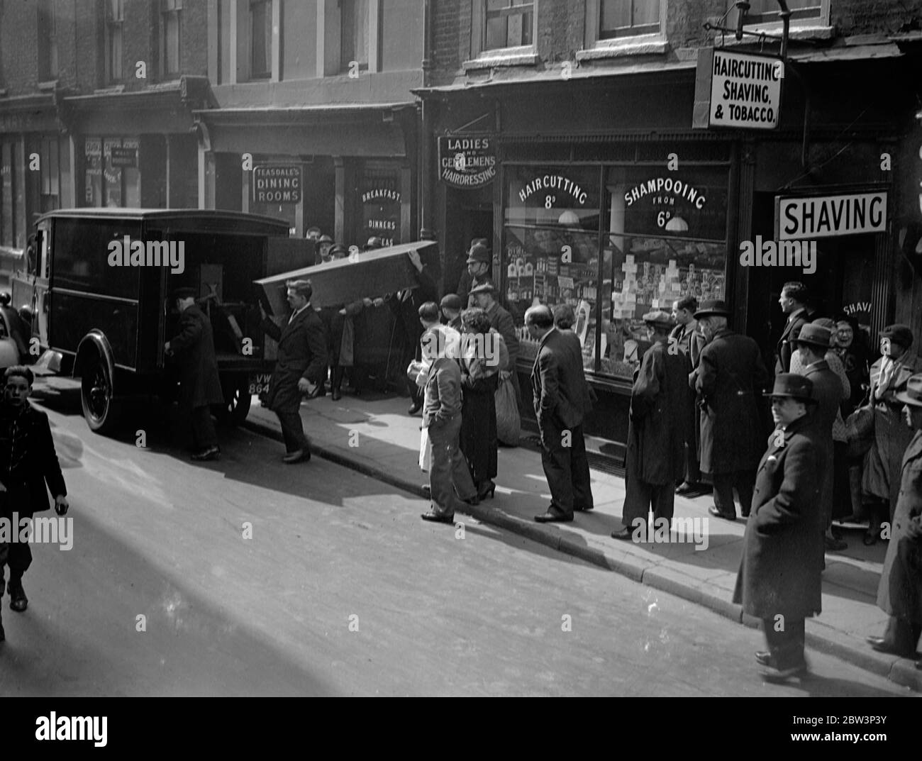Une femme a trouvé mort avec un foulard autour de son cou dans Soho plat . Mme Jeanette Cotton , âgée de 40 ans , a été trouvée morte dans un appartement à Lexington Street , Soho , avec une écharpe en soie attachée étroitement autour de son cou . la police croit que c'est un cas de meurtre . Le corps était entièrement vêtu , le visage était décoloré et il y avait du sang sur le foulard . La police suspecte meurtre . Photos montre , une foule regardant le corps être enlevé de l'appartement . 17 avril 1936 Banque D'Images