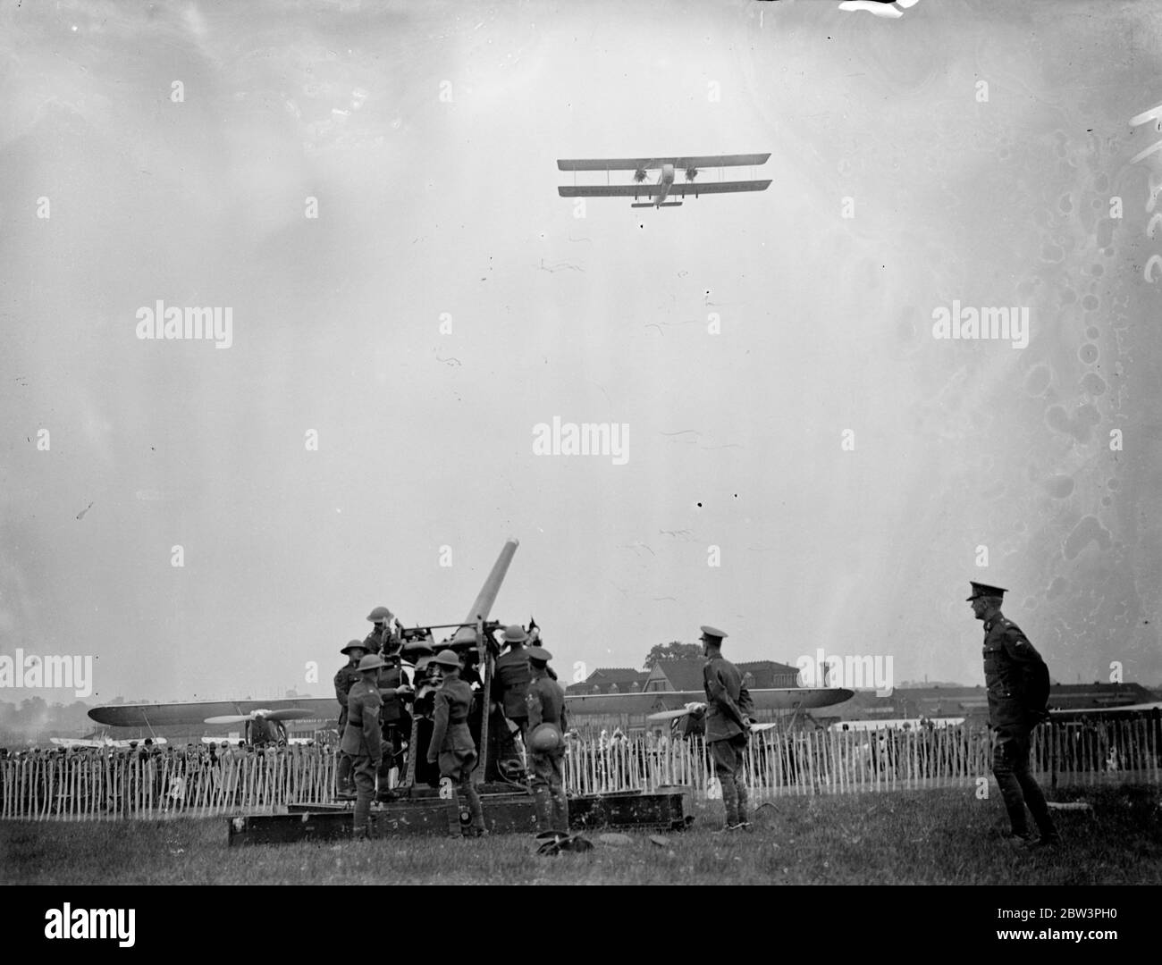 Les foules inspectent les avions à Hendon le jour de l'Empire. De grandes foules ont regardé l'exposition de l'Empire Air Day à l'aérodrome de Hendon , le 11e Régiment de Londres ( les Finsbury Rifles 0 , qui comprend maintenant les 170e et 171s batteries d'avions Anto co - exploité avec la Royal Air Force dans l'exposition . Expositions de photos , un Vickers de type 264 Valentia passant par-dessus un pistolet anti-avion de l'Artillerie royale . 23 avril 1936 Banque D'Images