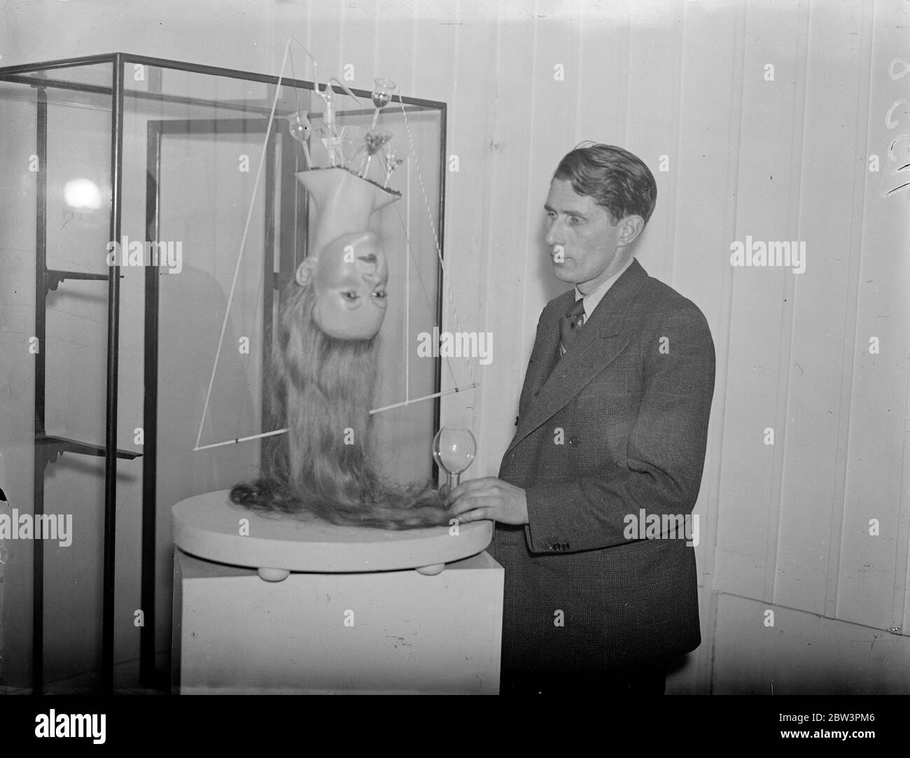 Des surréalistes exposent des œuvres à Londres . Les œuvres classées comme objets trouvés les objets interprétés , les objets perturbés et les objets construits sont en spectacle à l'exposition Surréaliste qui ouvre à la London Gallery à Oak Street , Piccadilly . Photos , M. Robert Penrose avec son exposition surréaliste ' Dew ' , qui est pour ' humidifier l'air vile des clubs , des bureaux , des banques , et des salles d'attente , etc . ' . 23 novembre 1937 Banque D'Images