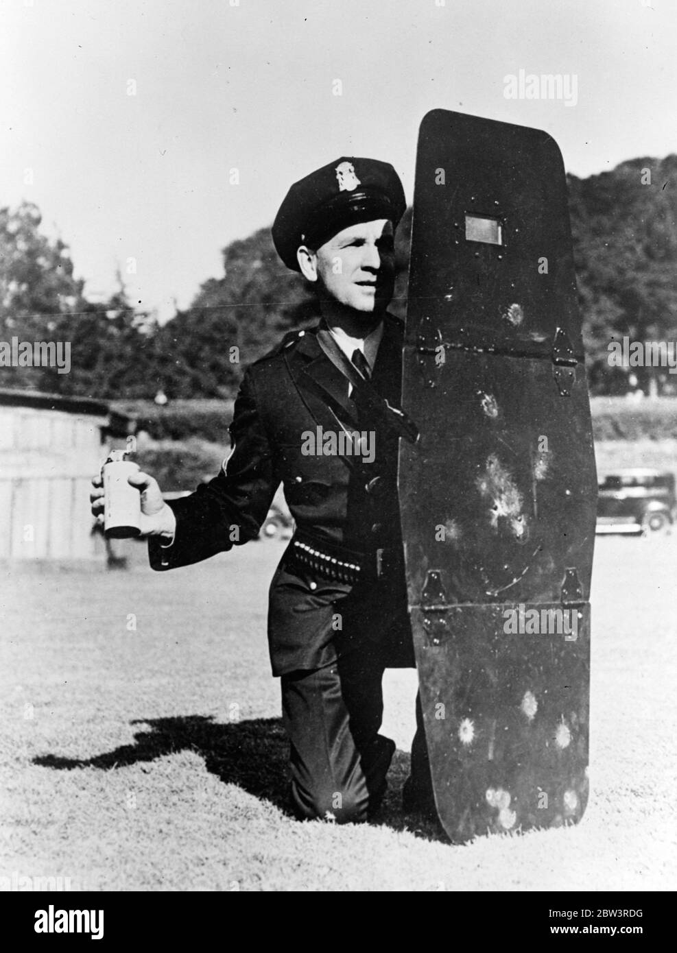 La police de San Francisco retourne aux boucliers . Le Sergent McInerney de la police de San Francisco faisant la démonstration du bouclier . Dans sa main il tient une bombe à gaz lacrymogène . 27 novembre 1935 Banque D'Images