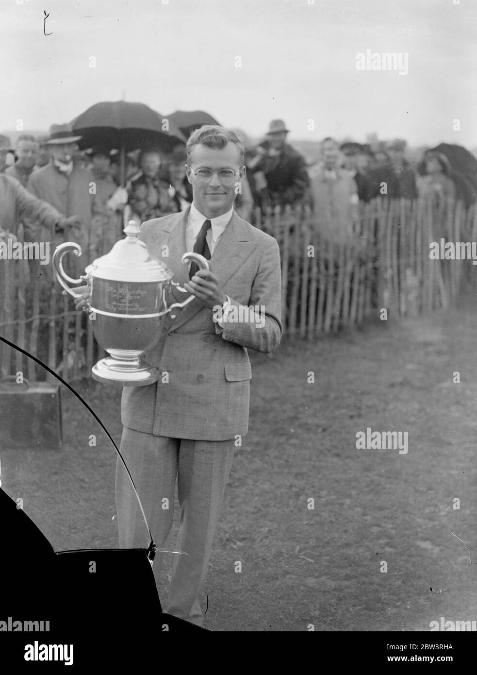 Gardner gagne la course aérienne de la coupe du roi . 164 MPH , moyenne malgré mauvais temps . Terminer le cours final à une vitesse moyenne de 164 . 5 miles par heure , MR Charles Gardner , volant d'une machine Percival Vega Gull , a gagné la course aérienne de la coupe du Roi et Lord Wakefield ' s 500 prix Premier prix dans l'aviation civile britannique . Lord Swinton , le ministre de l'Air , a présenté le trophée au gagnant . Le roi a envoyé ses félicitations par télégramme du Palais de Buckingham . Photos , Monsieur Charles Gardner vainqueur de la coupe du Roi , avec le trophée à Hatfield . 12 juillet 1936 Banque D'Images