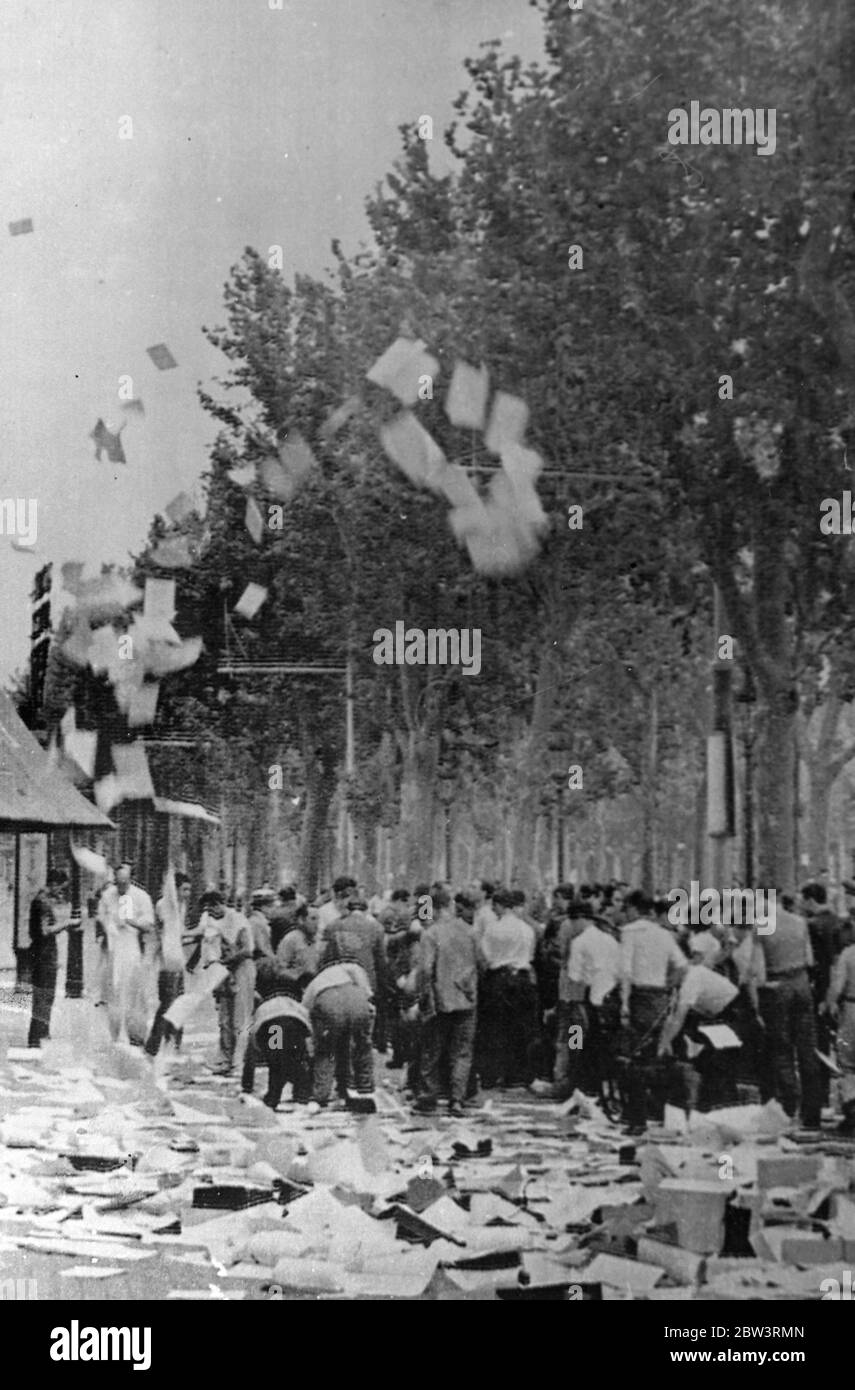 Barcelone Centre des combats les plus lourds de la guerre civile 8,000 morts . Barcelone a été le centre des plus lourds combats de la guerre civile. 8,000 personnes sont tuées dans les nombreuses batailles de rue et raids à la bombe . Le gouvernement prétend maintenant avoir le contrôle dans la ville . Ces photos ont été envoyées par avion à Marseille et téléphototées à Londres . Photos : les papiers et documents de diffusion de la foule dans les rues après un raid sur les bureaux fascistes de Barcelone . 23 juillet 1936 Banque D'Images