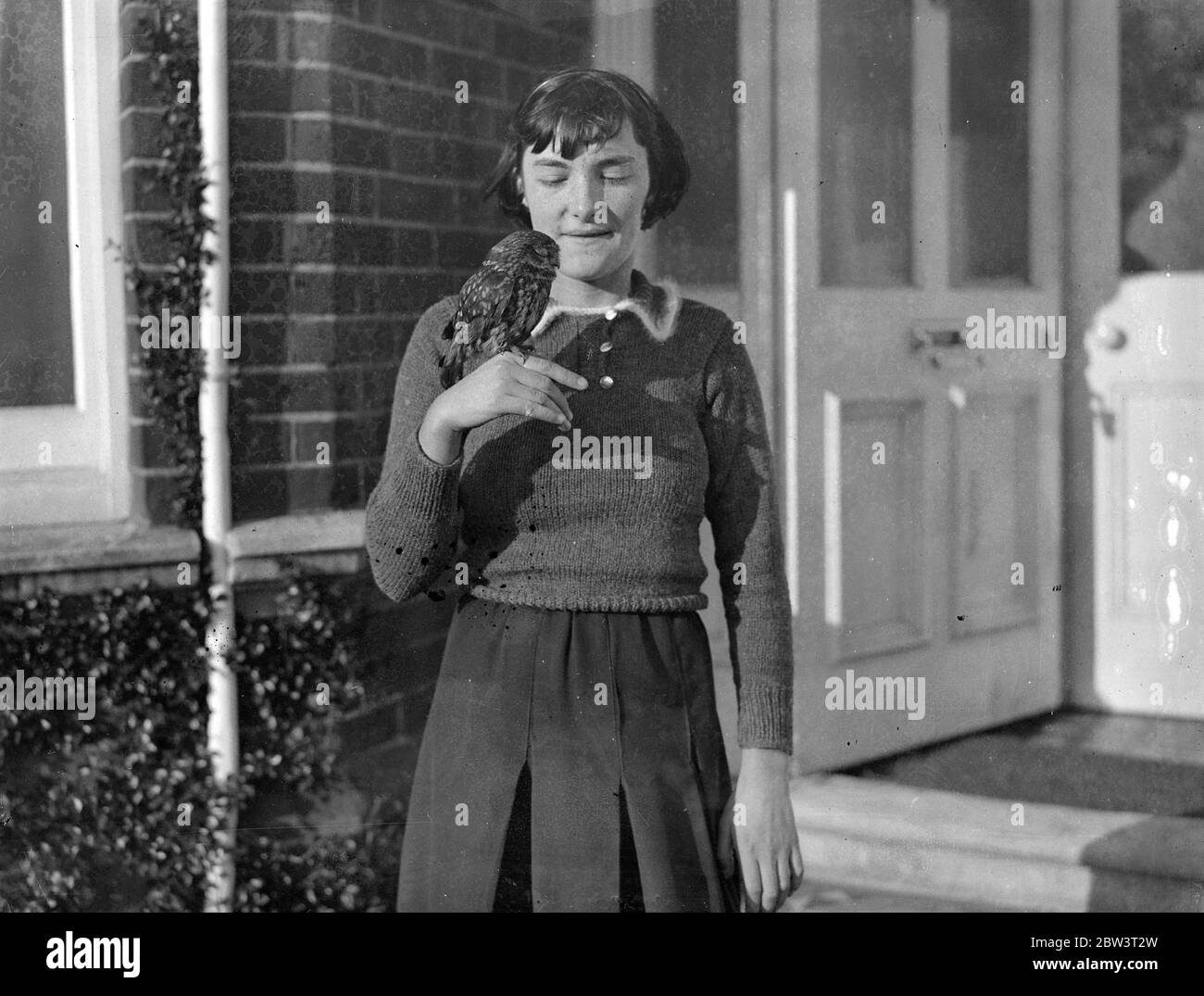 Hampshire fille réussit à garder la chouette comme animal de compagnie . Elle l'a sauvé de garçons espiègles - maintenant elle n'est jamais en retard pour l'école . Pete , la chouette brune , avec sa maîtresse , Jacqueline Veall . 8 décembre 1935 Banque D'Images