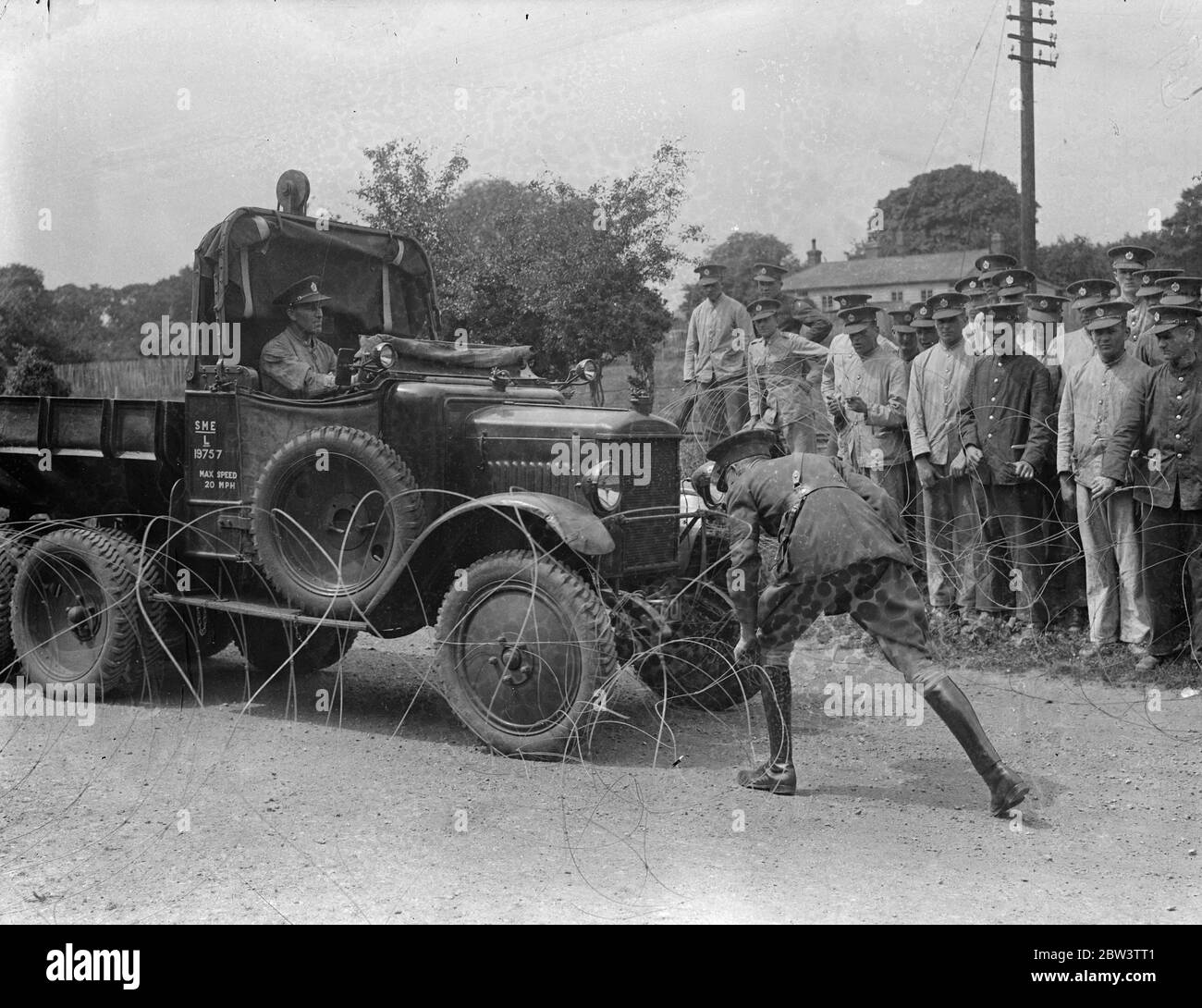 Véhicule de l'armée conduisant à travers le barrage de chemin barbelé [ à la démonstration des Royal Engineers . Les merveilles du génie militaire moderne ont été démontrées aux membres de l'École des officiers supérieurs de l'École de génie militaire et du dépôt des ingénieurs royaux de Chatham . La démonstration comprenait le camouflage , le pont - bâtiment et beaucoup d'autres types de guerre - ingénierie du temps . Photos : membres de l'école des officiers supérieurs observant un camion de l'armée qui traverse un bloc de route barbelé 11 juin 1936 Banque D'Images