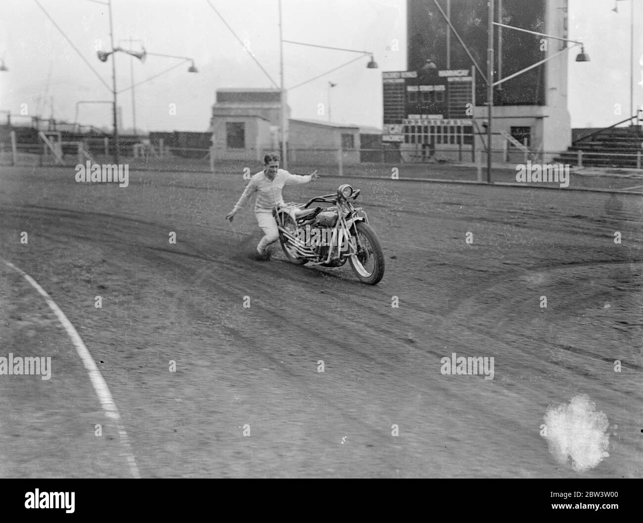 Il ' s au-dessus du cyclisme de moteur ordinaire ! Une exposition à couper le souffle de l'acrobatique à vélo a été donnée au Hackney Wick Stadium , Londres , par Putt Mossman et des membres de son équipe de pilotes de course . Pour aider Mossman dans ses cascades, il y a son épouse , Mme Helen Mossman , et sa sœur , Mlle Dessie Grant . Mossman est la première équipe de course américaine à visiter l'Angleterre et ils doivent avoir des rencontres avec des équipes britanniques . Photos , Putt Mossman donne une démonstration de la commande ' à distance ' ! . 25 mai 1936 Banque D'Images