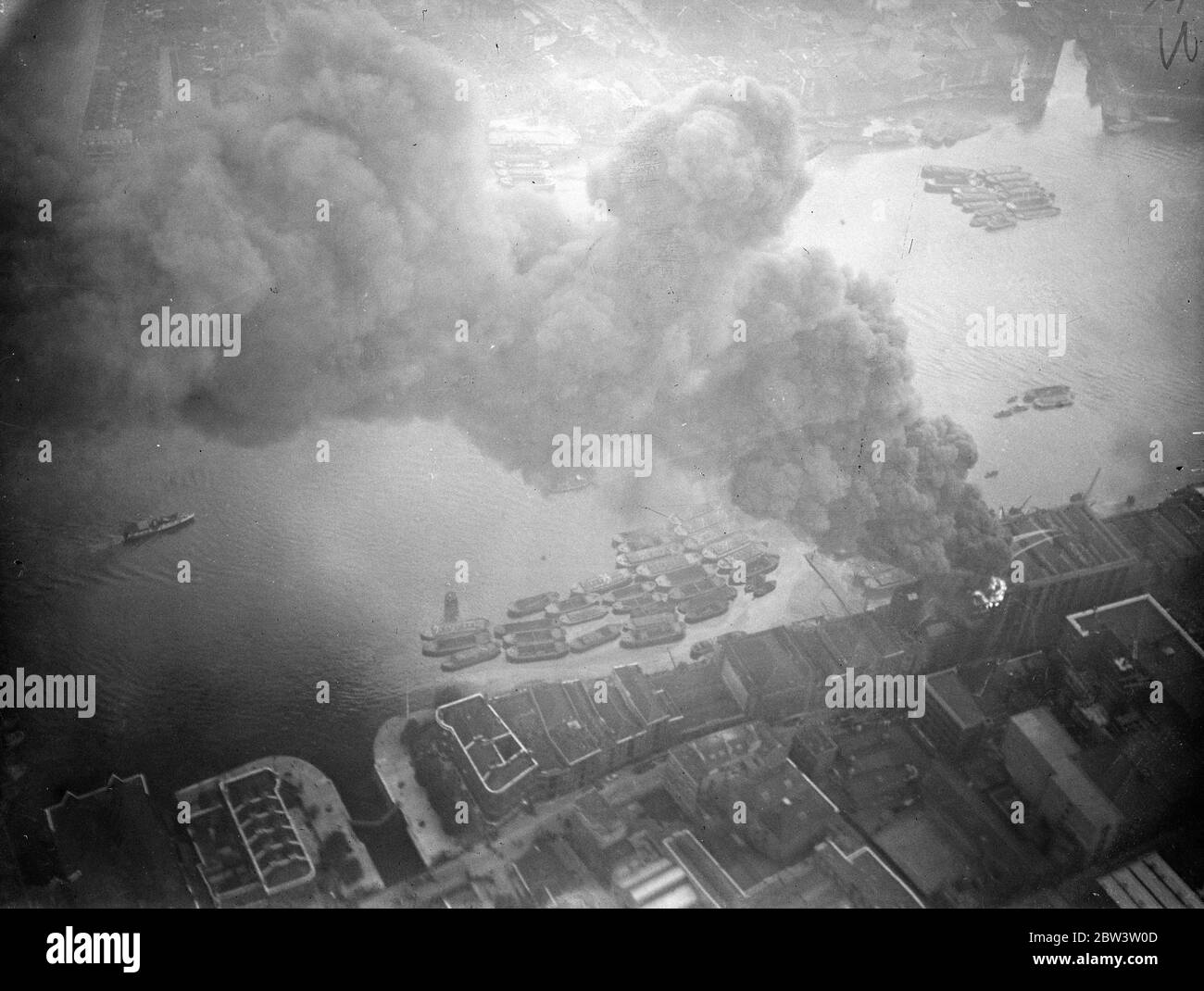 Les flotteurs de feu combattent le grand entrepôt de thé, qui menace le dockland de Londres . Combattre les flammes du feu flotte sur la Tamise . L'entrepôt flamboyant - image de l'air . 25 septembre 1935 Banque D'Images