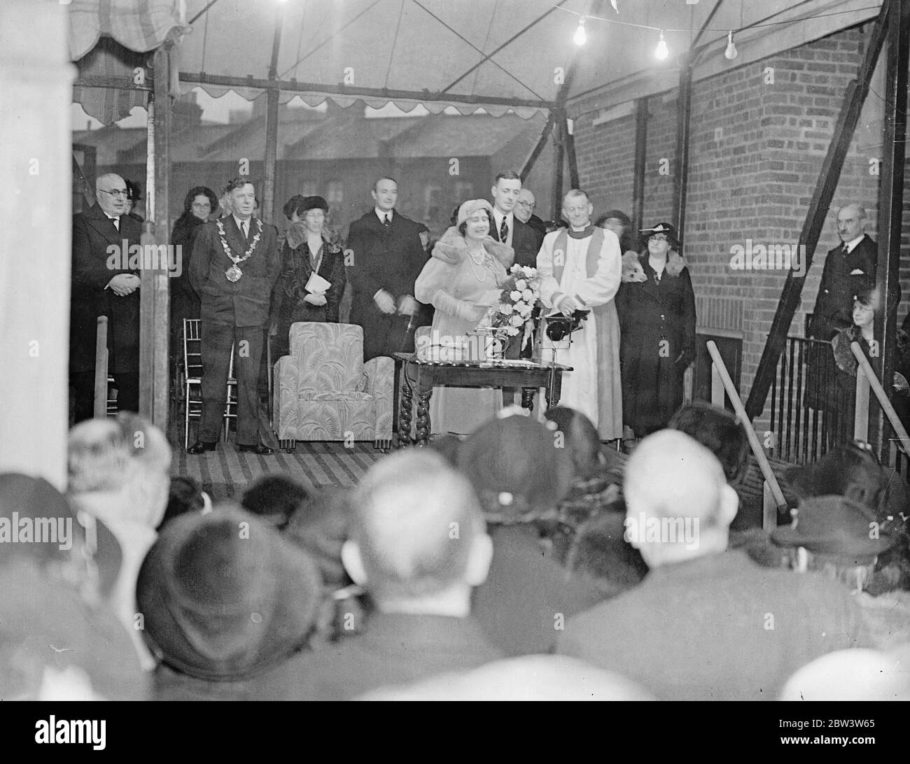 La duchesse de York ouvre de nouveaux appartements à Isle Dogs . La duchesse de York , qui n'a pas pu assister au baptême du bébé prince en raison de l'engagement préalable , ouvre l'île des chiens , le premier bloc d'appartements de la Housing Society à la maison de St Hubert , Janet Street , l'île des chiens . Photos , la duchesse de York recevant un bouquet lors de la cérémonie d'ouverture . 20 novembre 1935 Banque D'Images