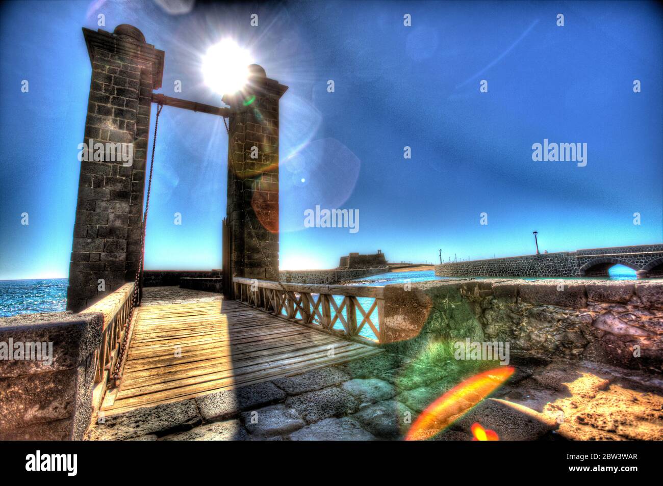 Île de Lanzarote, Espagne. Vue artistique détourée du pont Puente de Las Bolas d'Arrecife, avec le Castillo de San Gabriel en arrière-plan. Banque D'Images