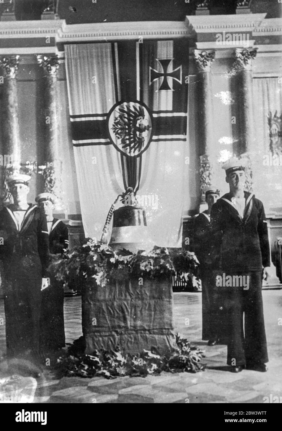 La Marine britannique remet la cloche de Hindenburg à la Marine allemande . La cloche du navire de guerre allemand Hindenburg qui a été coulé à Scapa Flow a été remise à la marine allemande de Kiel par le croiseur britannique Neptune . La cloche a été reçue par le général - amiral Erich Raeder , commandant - en chef de la Marine allemande . Photos : marins britanniques de la garde debout Neptune au-dessus de la cloche Hindenburg à Kiel . 17 août 1936 Banque D'Images