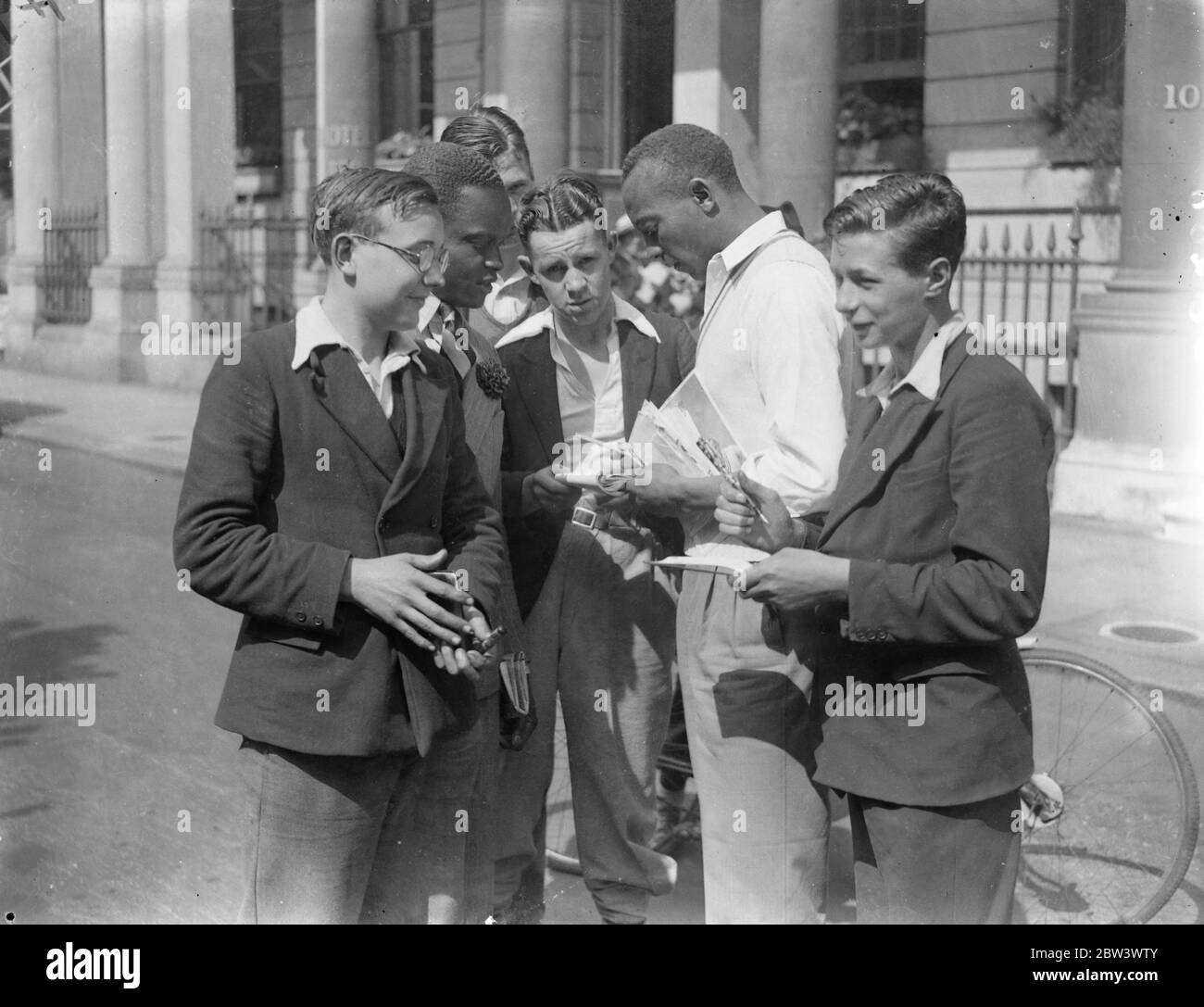 Jesse Owens Falls aux chasseurs autographes , pour participer à l'Empire britannique , USA Athletics demain . Jesse Owens , le ' Black Panther ' et vainqueur des médailles d'or olympiques de 3 , a présenté une démonstration aux garçons de Londres qui l'ont assiégé pour la corruption de ressources à son hôtel après son arrivée d'Allemagne . Owens doit participer à l'Empire britannique , à l'athlétisme des États-Unis à la ville Blanche ( samedi ) . Expositions de photos, Jesse Owens signant des autographes devant son hôtel de Londres. 14 août 1936 Banque D'Images