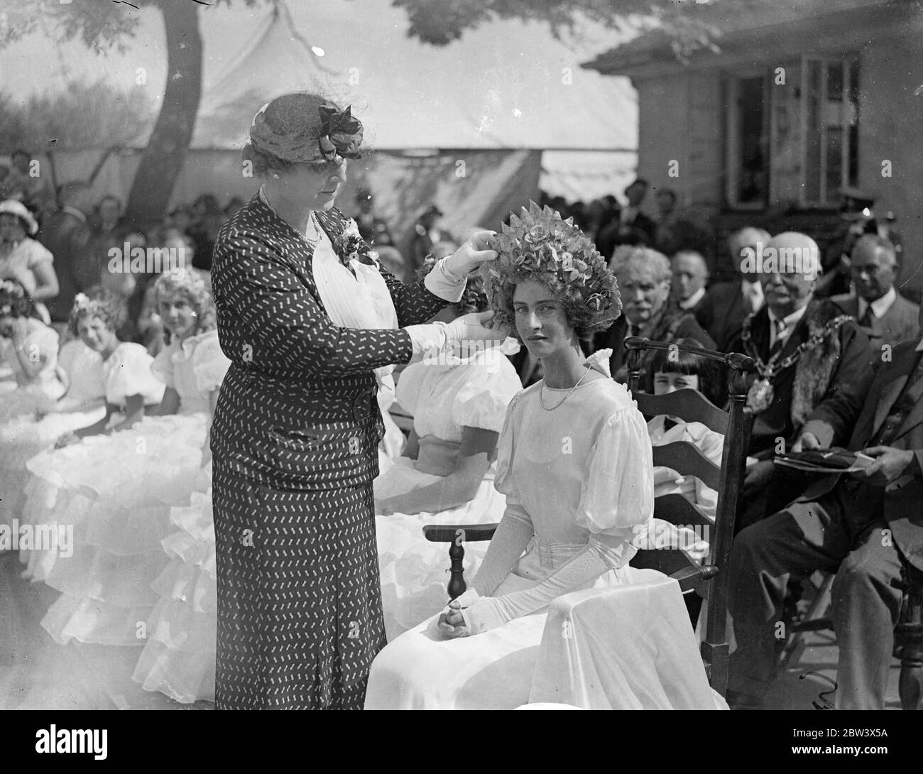 Couronnement de la Reine florale à la grande tête florale à Oxford . La fête florale annuelle organisée par le Great Western Railway social and Education Union , et l'un des plus grands événements de ce genre dans le pays , s'est tenue à Oxford . L'objectif de l'événement est d'encourager les employés de G W R à cultiver des fleurs , des fruits et des légumes . Photos , Lady Thomas , épouse de Sir W James Thomas , Bt , Présidente de l' Union , couronnant la Reine florale , Mlle Dorothy Snow de Didcot . 22 août 1936 Légende originale de négatif Banque D'Images