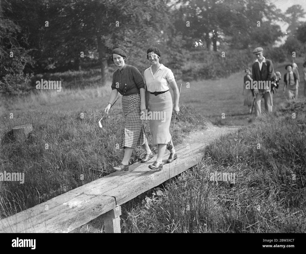 Demi-finales de championnat de golf pour filles à Stoke Poges . Les demi-finales du Championnat de golf de filles ont eu lieu à Stoke Poges . Jessie Bexter ( Bishopbriggs , Glasgow ) s'opposa à Peggy Edwards ( Manchester ) et Jacqueline Gordon ( Stanmore ) rencontrèrent Sheila Stroyan , capitaine écossais . Photos , Miss Jacqueline Gordon , ( à gauche ) et Miss Sheila Stroyan traversant le pont au troisième . 11 septembre 1936 Banque D'Images