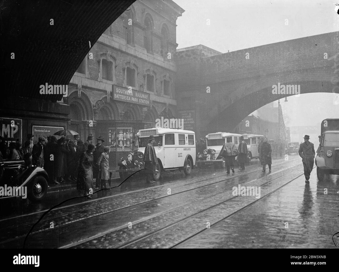 Trois personnes étaient connues pour être mortes, d'autres auraient perdu la vie et beaucoup ont été blessées lorsque deux trains électriques ont heurté le pont de Fourspan entre Queens Road et la gare de Battersea Park. Les cars étaient télécopés et rentournés. Photos montre: Une ligne d'ambulances attendant d'emmener les blessés à l'hôpital. 2 avril 1937 Banque D'Images