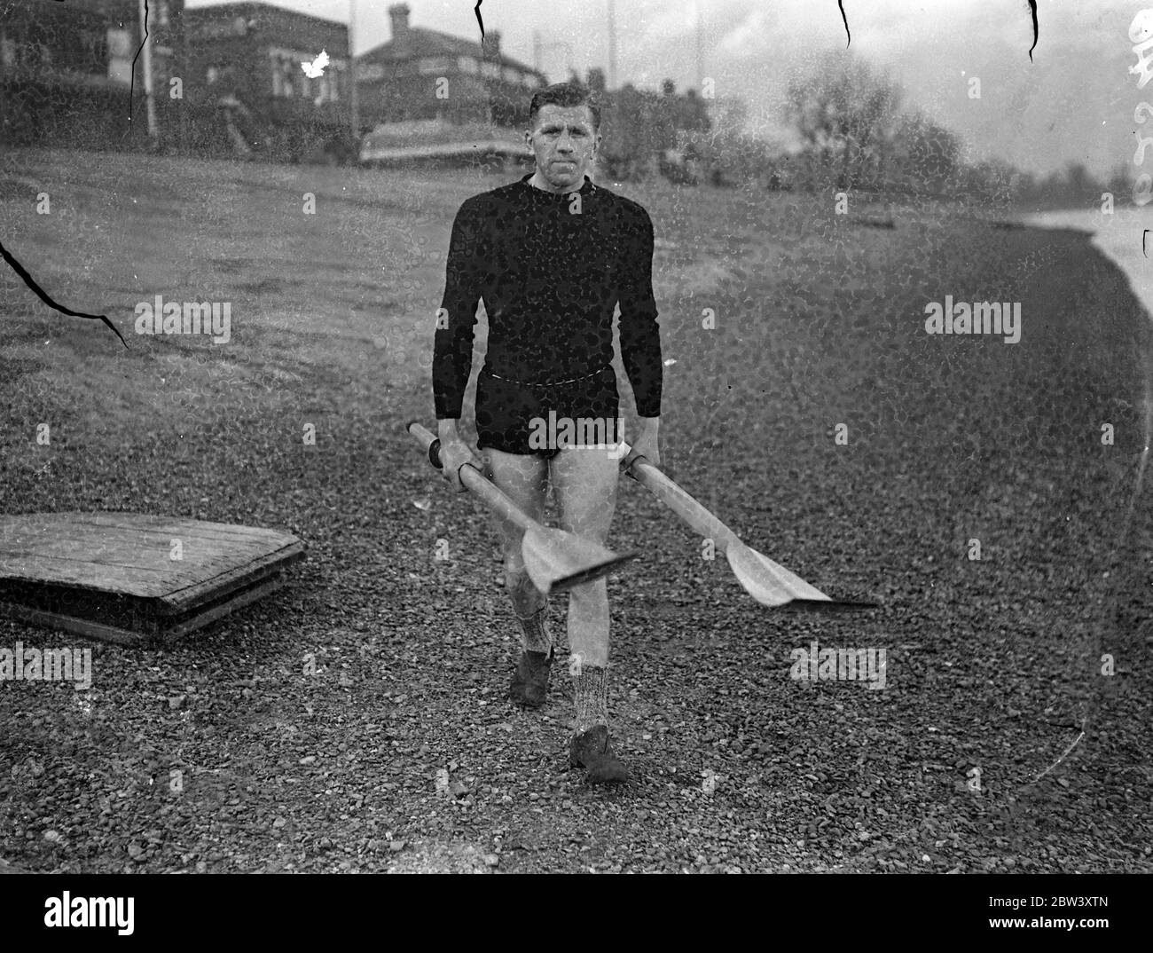 Eric Phelps s'entraîne pour conserver le titre de chabling . Le bargemaster du roi aide son . Eric Phelps , le titulaire , s'entraîne à Putney pour défendre son titre professionnel de champion de chabling Lou Barry , un ancien champion , dans leur course du lundi de Pâques sur le parcours Putney à Mortlake . ' Bossy ' Phelps , le Bargemaster du roi , aide son fils dans sa formation . Photospectacles , Eric Phelps , portant ses chaboisseaux à la rivière pour la pratique à Putney . 18 mars 1937 Banque D'Images