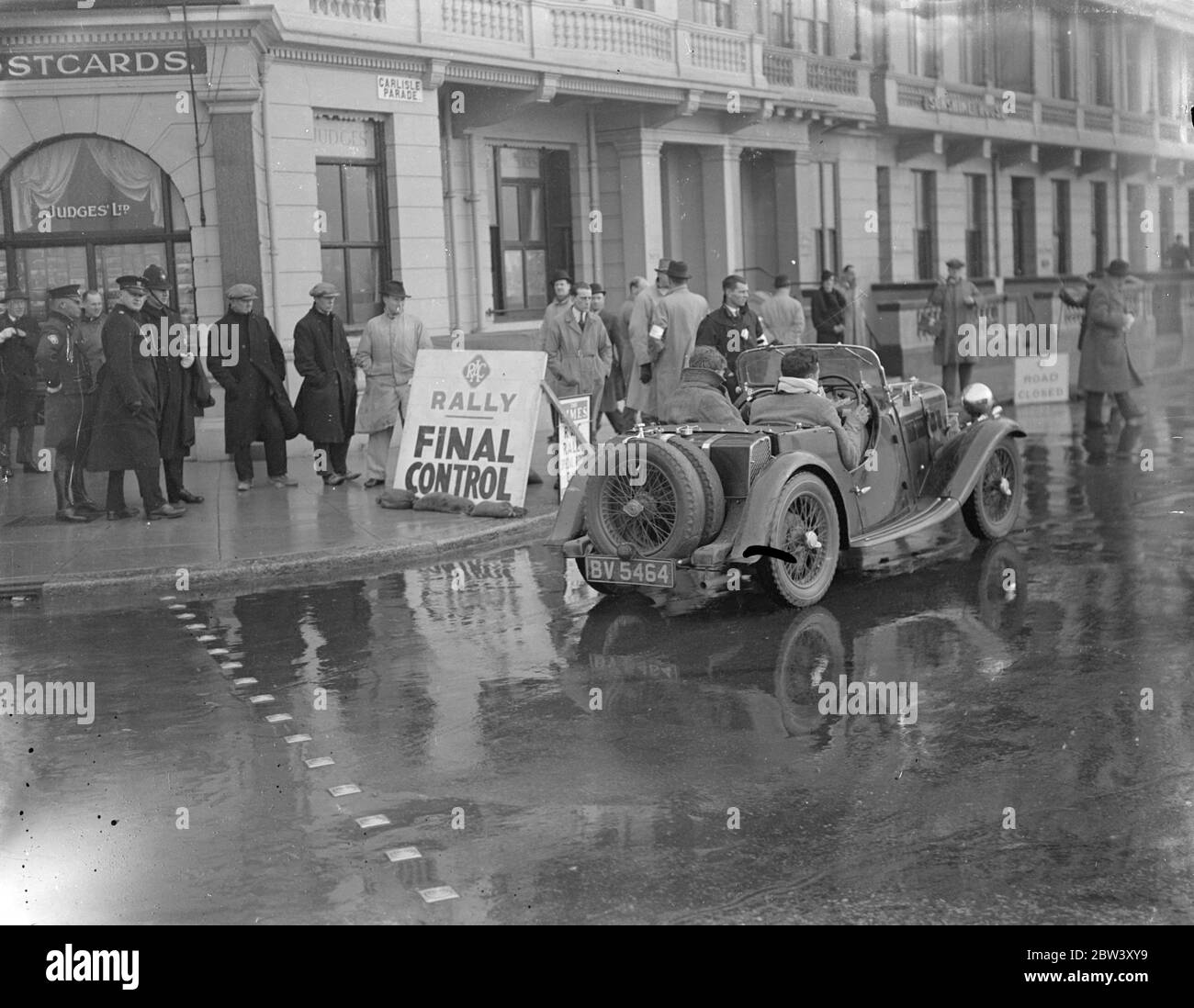 Les concurrents du RAC Rally terminent à Hastings . Après avoir passé deux jours et nuits sur un horrible parcours de mille concurrents dans le RAC , Rally est arrivé à Hastings , le point d'arrivée . Photos , un des concurrents arrivant au contrôle final à Hastings . 11 mars 1937 Banque D'Images