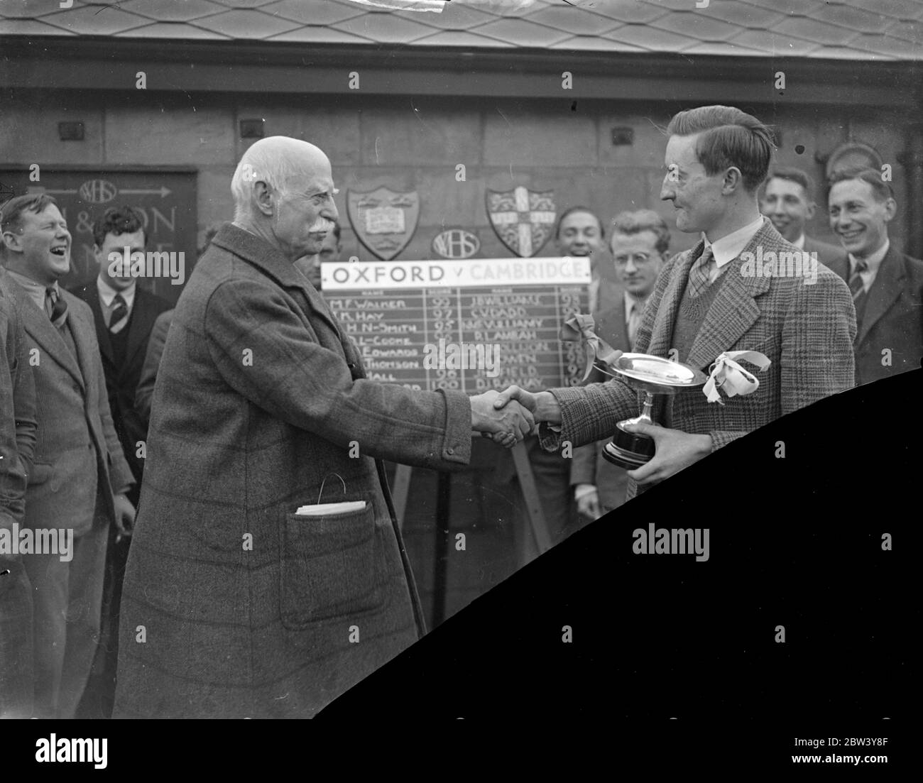 Cambridge a battu Oxford lors d'un match annuel de tir à la carabine à Londres. L'université de Cambridge a battu l'université d'Oxford de 785 points contre 777 dans le 12e match annuel de tir à la carabine pour le trophée défi Heslop tenu sur la gamme de tir de toit de W H Smith and son, Ltd., Strand House, Portugal Street, Kingsway. Expositions de photos : le lieutenant-général Sir A. Codrington présente le trophée au capitaine de Cambridge, le D J Ramsay. L'équipe gagnante est sur la droite. 25 février 1937 Banque D'Images