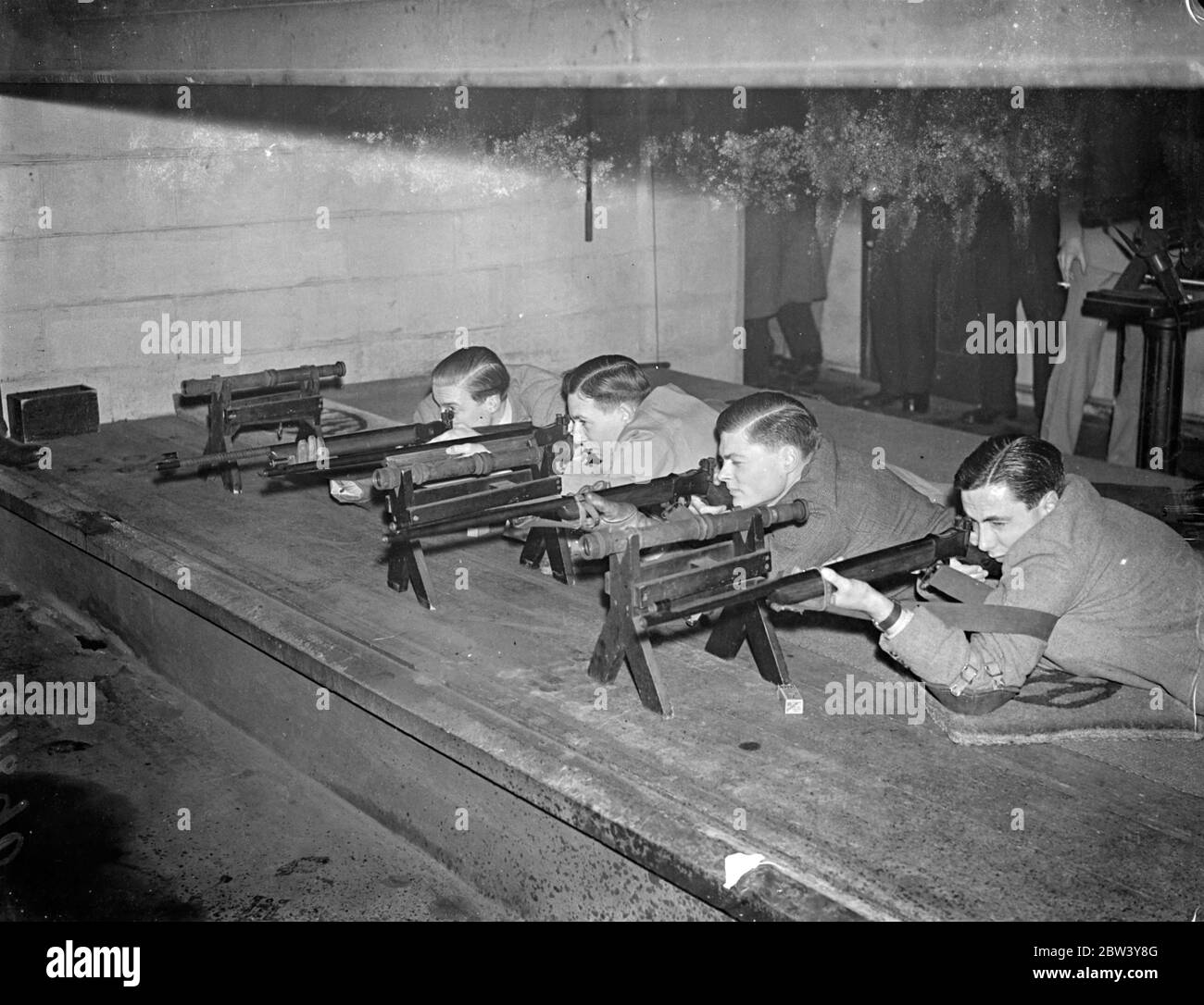 Cambridge a battu Oxford lors d'un match annuel de tir à la carabine à Londres. L'université de Cambridge a battu l'université d'Oxford de 785 points contre 777 dans le 12e match annuel de tir à la carabine pour le trophée défi Heslop tenu sur la gamme de tir de toit de W H Smith and son, Ltd., Strand House, Portugal Street, Kingsway. Photos montre: - de gauche à droite- J. B. Williams (Cambridge) C. V. Dadd (Cambridge); J. K. Hay (Oxford) et F. C. Walker (capitaine d'Oxford) au point de tir. 25 février 1937 Banque D'Images