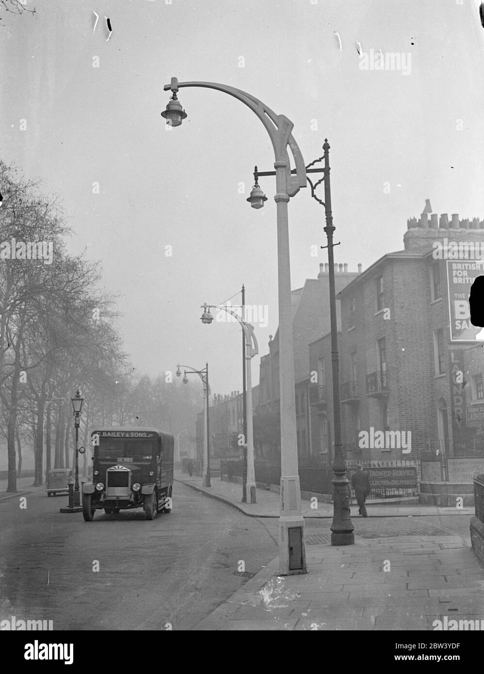 Nouvelles lampes pour l'ancien à Fulham. De nouvelles normes intelligentes de lampes sont érigées dans le chemin New King, Fulham, dans le cadre du projet du ministre des Transports visant à améliorer l'éclairage de la rue. Photos : l'une des nouvelles lampes est située sur la route du Nouveau Roi, avec l'un des anciens types en arrière-plan. 4 mars 1937 Banque D'Images