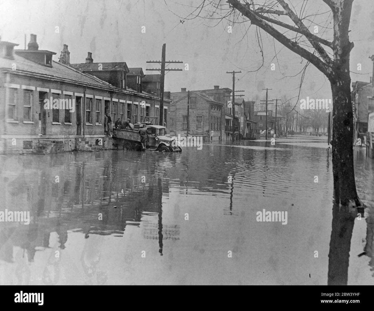 Des centaines de morts , des millions de sans-abri et des inondations aux États-Unis sont encore en hausse . Feu , fièvre et pillards menace les villes . Harcelé par les eaux en constante augmentation , mais les feux de pétrole , fièvre épidémies de pillages , les agriculteurs et les citadins des vallées du Mississippi et de l'Ohio sont confrontés à la mort dans les pires inondations depuis 10 ans . Près de 400 000 personnes sont mortes et 1 million sont sans abri . Les avions lardent les approvisionnements de troupes fédérales renforcent la Garde nationale pour mettre en place le pillage et évacuer les zones inondées . Photos de spectacles , évacuation d'une famille à Newport , Kentu Banque D'Images