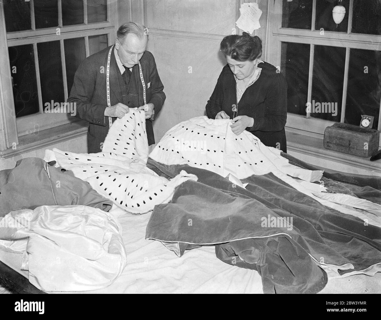 Robes de chambre de pairs pour Coronation fabriquées à Londres. Velours et hermine tissés à la main - coût £200. Les magnifiques robes rouges et blanches de velours et d'hermine que les pairs et les peeresses portent au Coronation en mai prochain sont fabriquées à la main dans les salles de travail du West End de MM. Wilkinson, les tailleurs de la Cour. Près de 20 mètres de velours tissé à la main sont utilisés pour faire un peignoir, qui une fois achevé peut coûter jusqu'à 200 £. La différence de rang dans le cas des pairs est indiquée seulement par la variation des rangées de taches de fourrure noire laisser dans l'ermine. Pour les péeresses, la seule marque distinctive est la longueur du train. Photo Banque D'Images