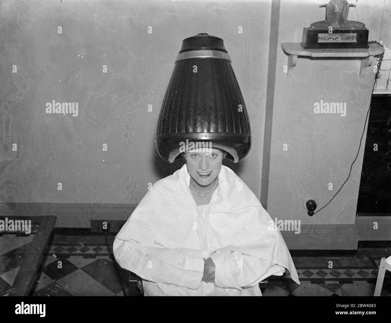 Les coiffeurs vont ' High Hat ' ! . De nombreuses nouvelles coiffure saisissantes et les derniers appareils de culture de beauté seront en vue à la Foire de cheveux et de beauté qui aura lieu à Olympia , Londres la semaine prochaine . Expositions de photos , le sèche-cheveux High Hat qui sera sur la vue à la foire . 19 septembre 1936 Banque D'Images