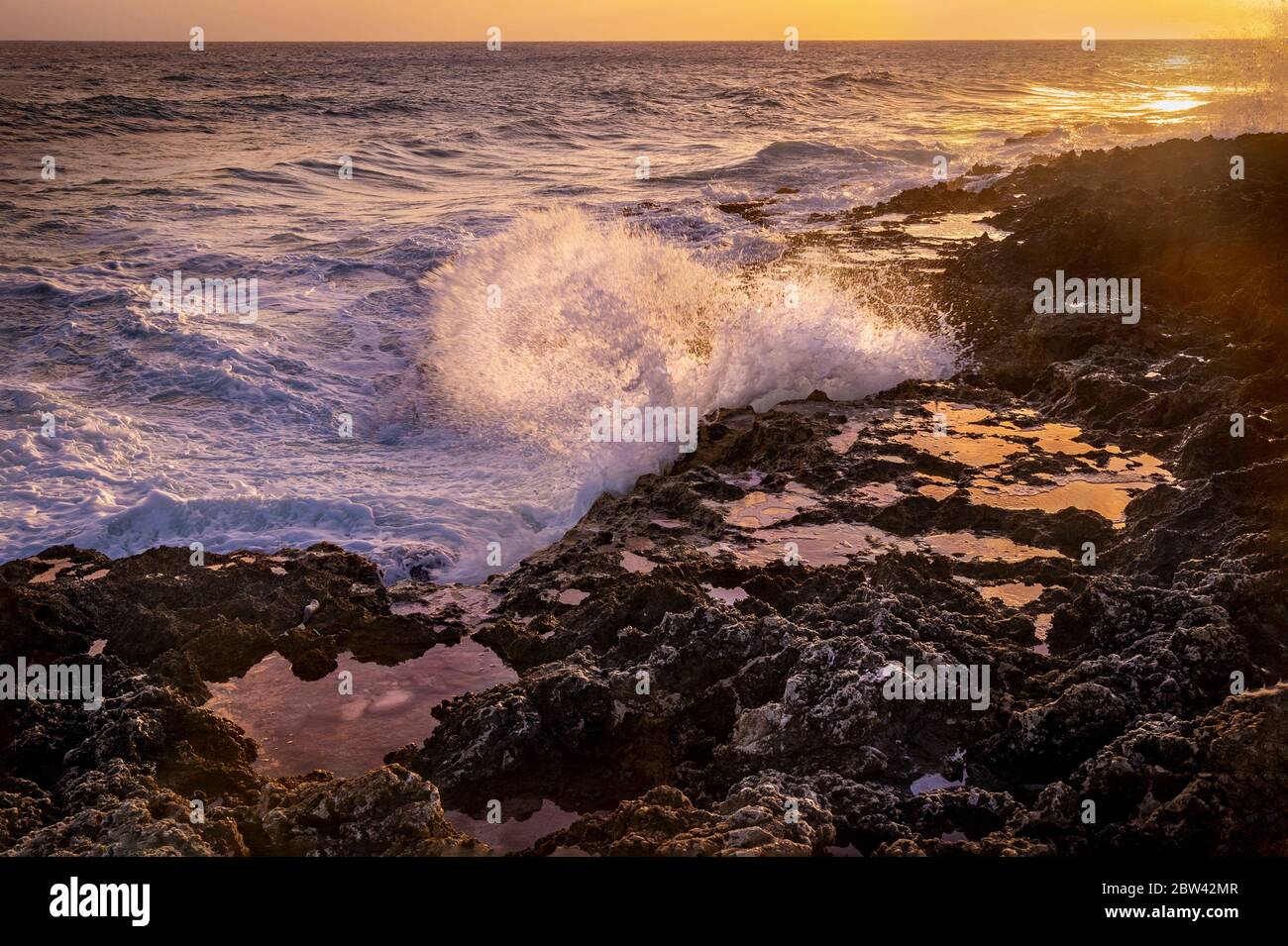 De grandes vagues s'écrasant contre les rochers au coucher du soleil, Grand Cayman Blowholes Banque D'Images
