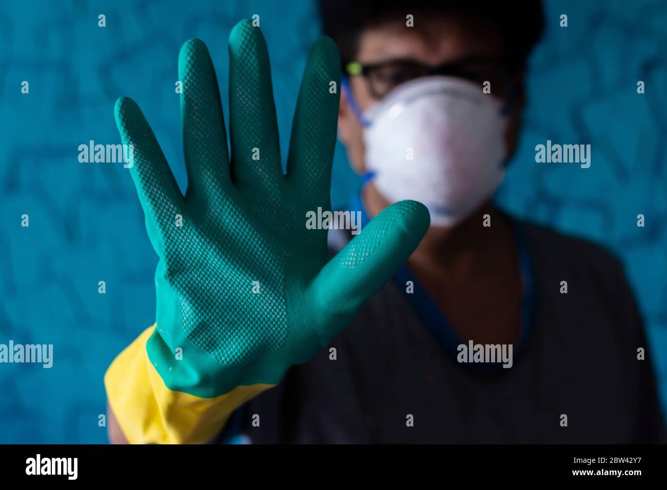 Un homme portant un masque et des gants pour les mains qui avertissent de rester protégé Banque D'Images