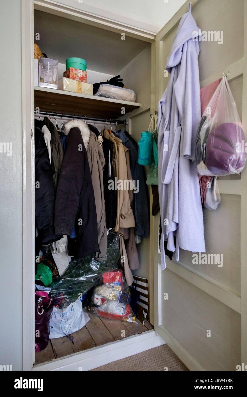 Vêtements suspendus dans des placards de maison appartenant à une femme âgée récemment décédée, Royaume-Uni. Banque D'Images Vêtements suspendus dans des placards de maison appartenant à une femme âgée récemment décédée, Royaume-Uni. Banque D'Images